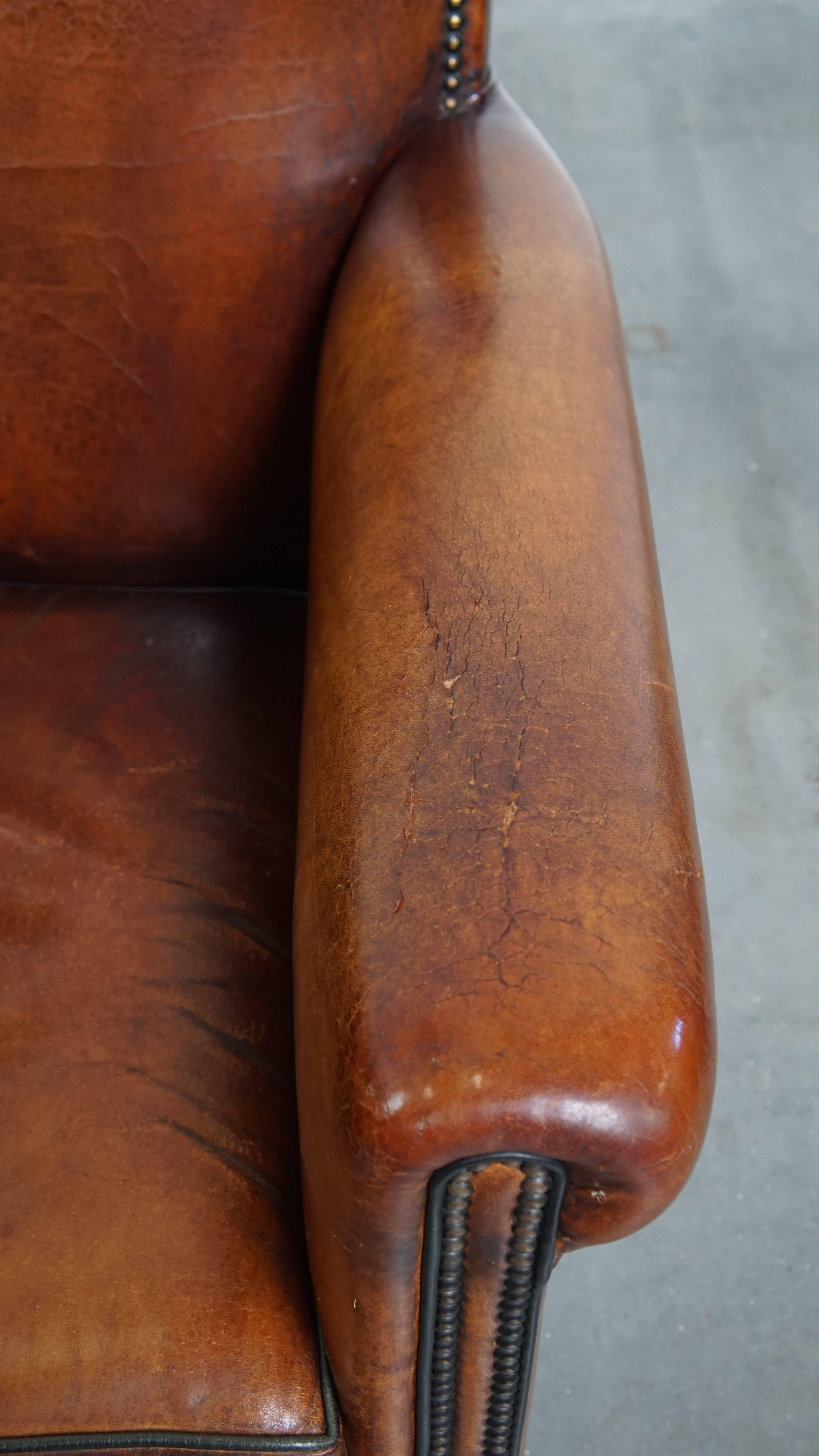 Sheepskin leather armchair in a cognac color with black piping For Sale 1