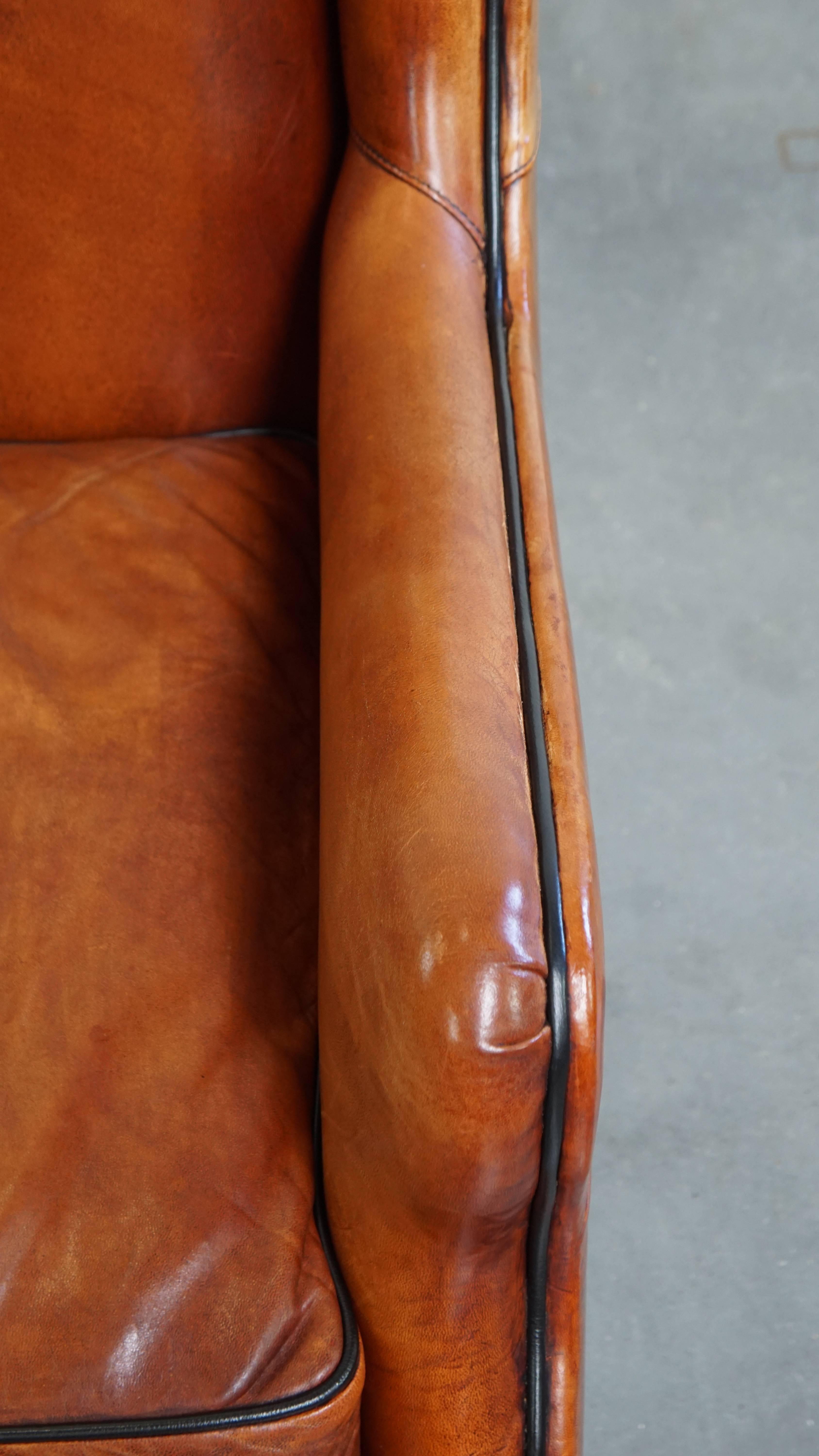 Sillón de piel de oveja con respaldo alto y ribetes negros en venta 1