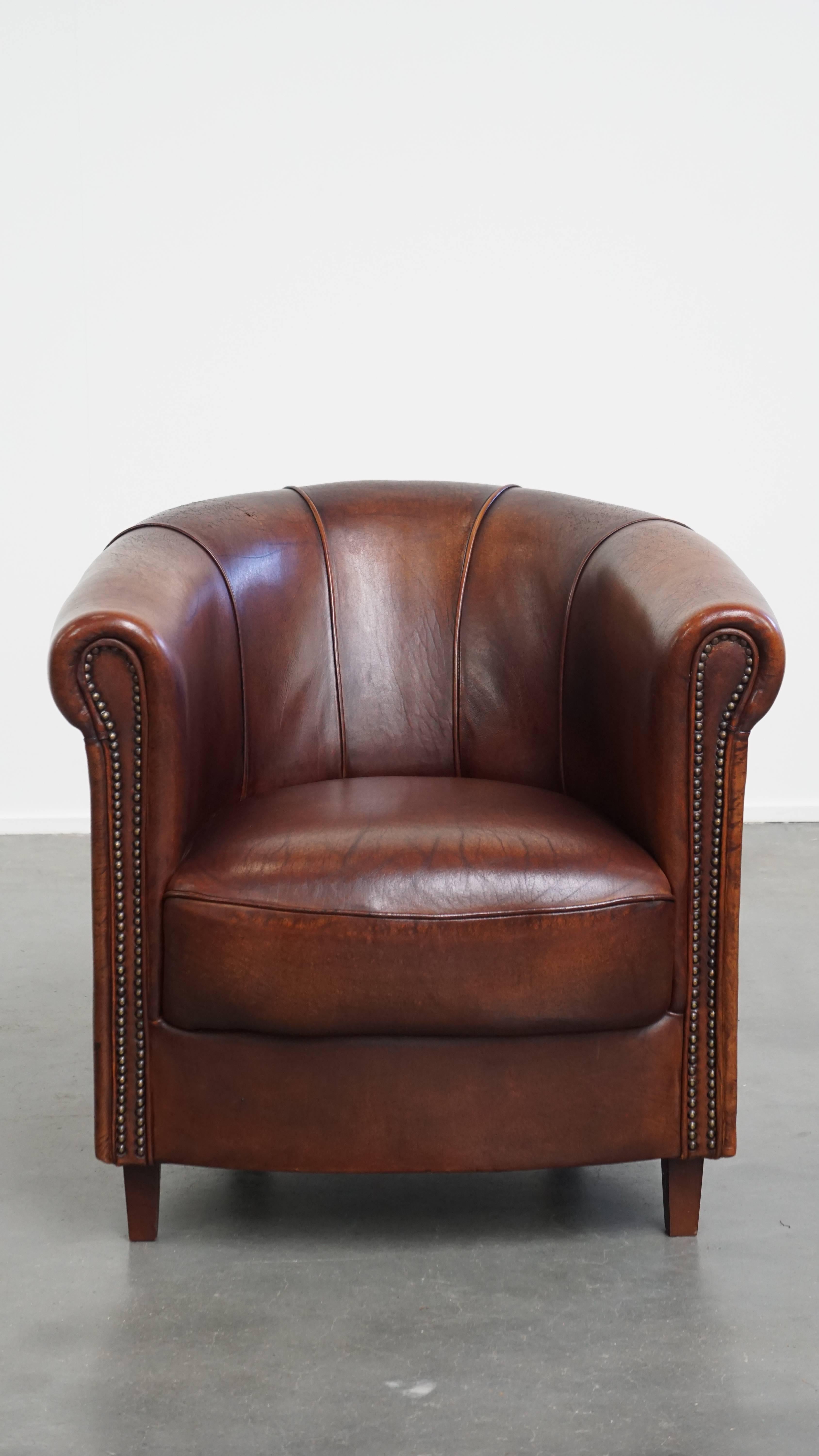 Qui viene offerta questa elegante poltrona club in pelle di pecora in un bellissimo color cognac scuro con dettagli raffinati.

Questa poltrona club in pelle di pecora è caratterizzata da una splendida tonalità cognac scuro e si adatta perfettamente