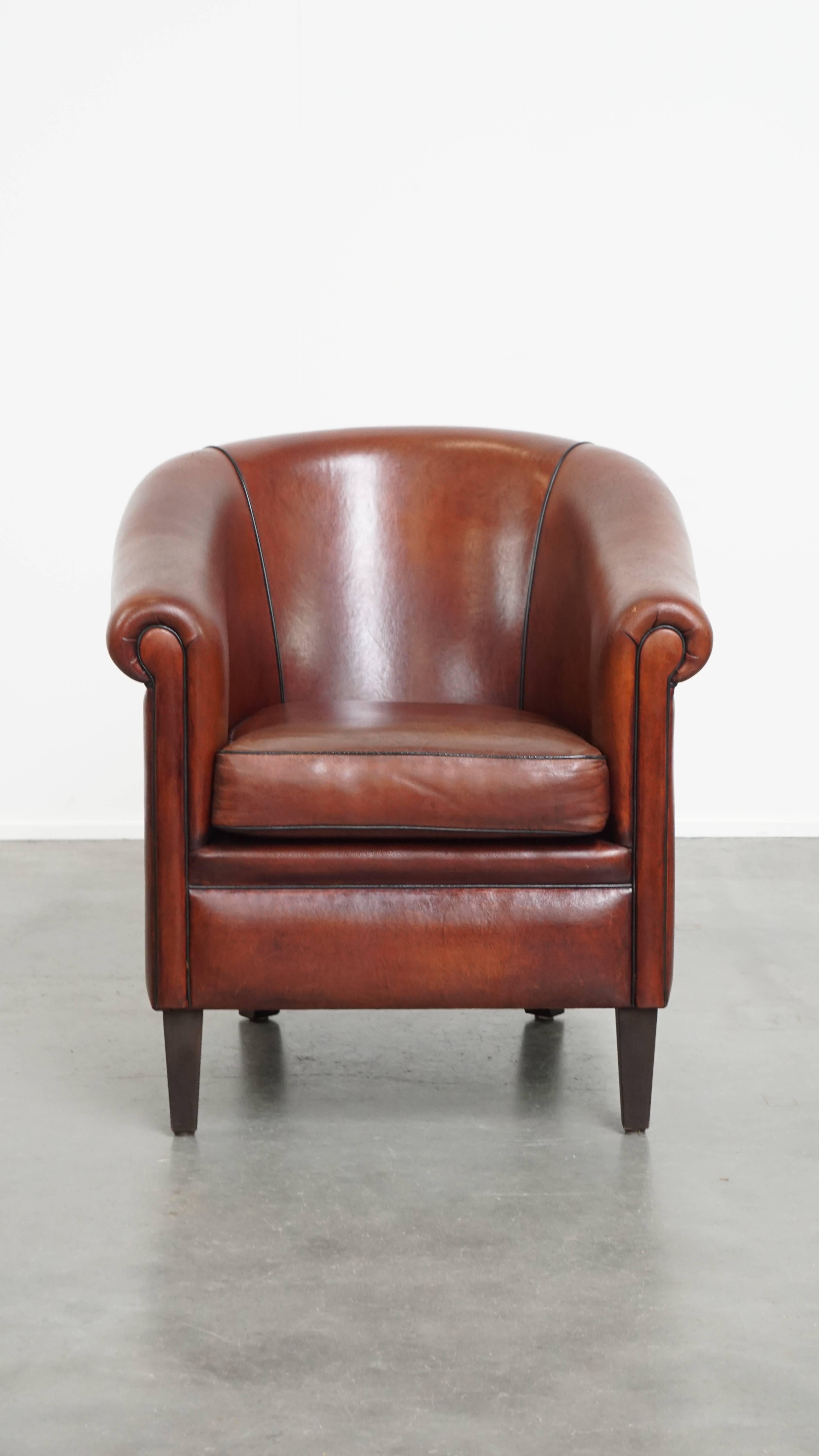 Se ofrece: este precioso sillón club de piel de cordero intemporal en un tono cálido y profundo, acabado con ribetes negros. Este sillón club de piel de cordero desprende una calidez impresionante, realzada por su rico color. A lo largo de los años,