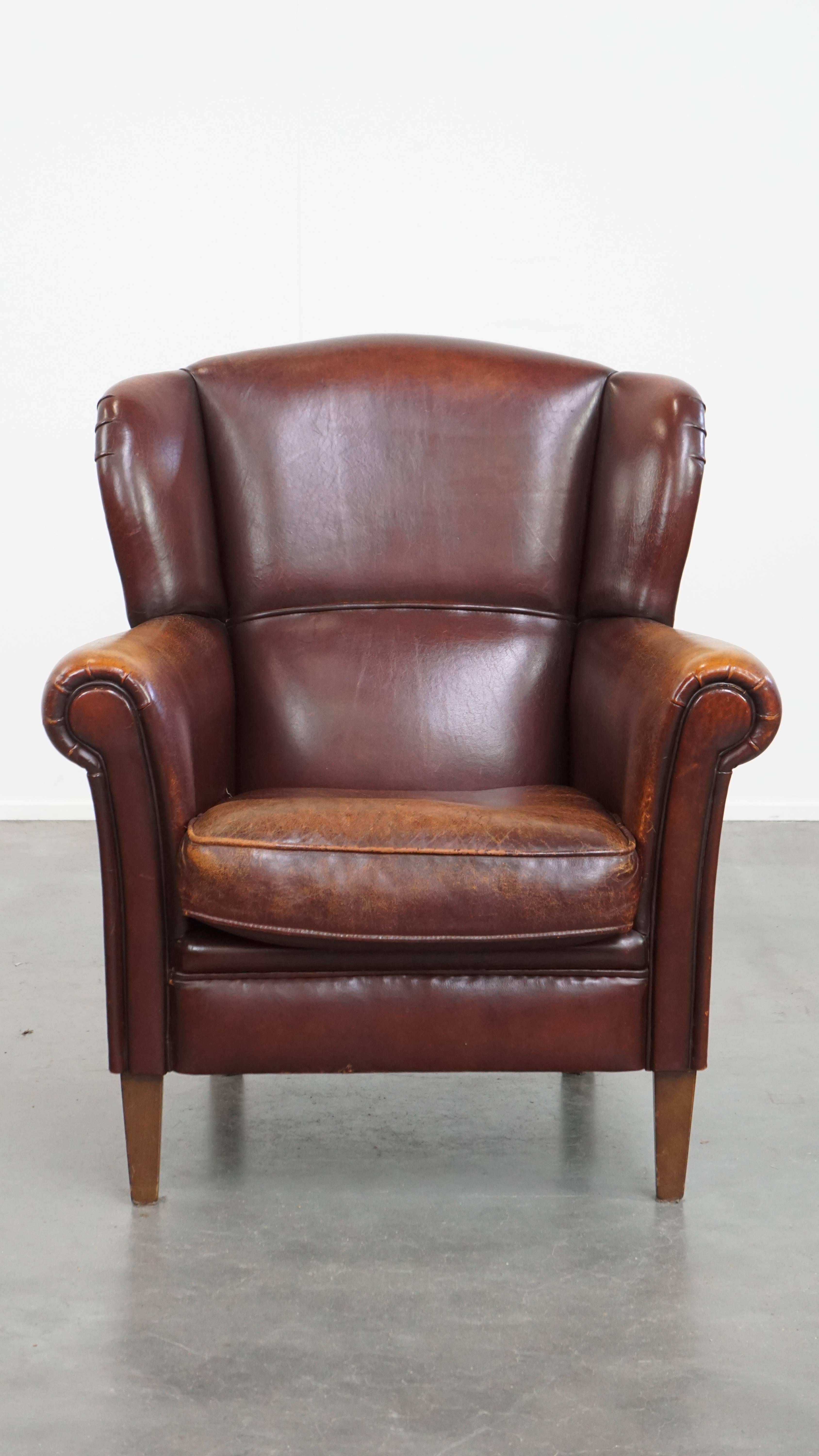 Offered: this characterful sheepskin leather wingback armchair with a dark warm colour scheme and a beautiful patina. This lovely sheepskin wingback chair is a stylish and comfortable addition to nearly any interior.

Through years of careful use,