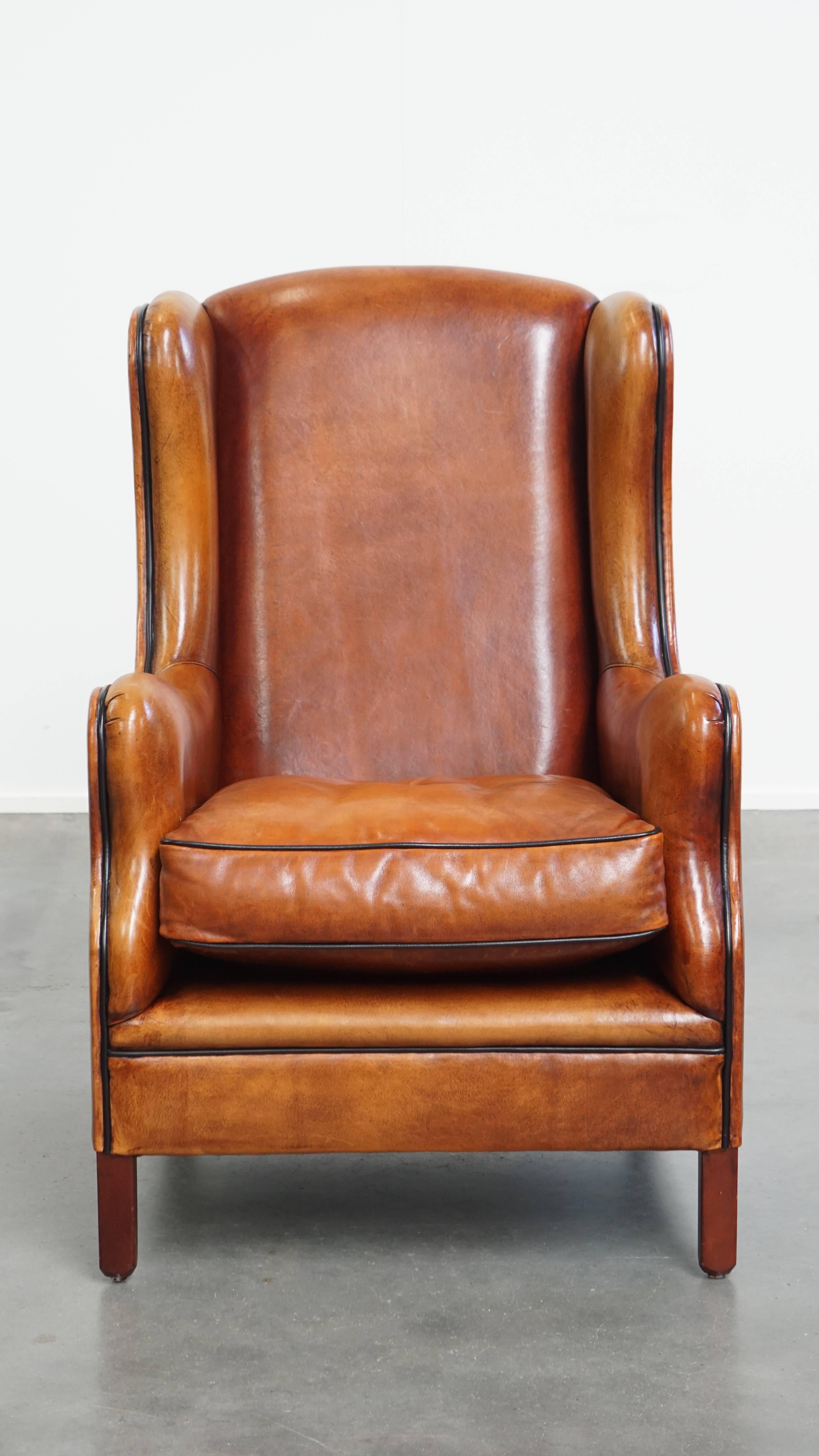 Te presentamos este característico sillón orejero de piel de cordero con un diseño atemporal y ribetes negros.

Este elegante sillón orejero presenta refinados detalles con ribetes negros y, gracias a su diseño atemporal, encaja sin esfuerzo tanto