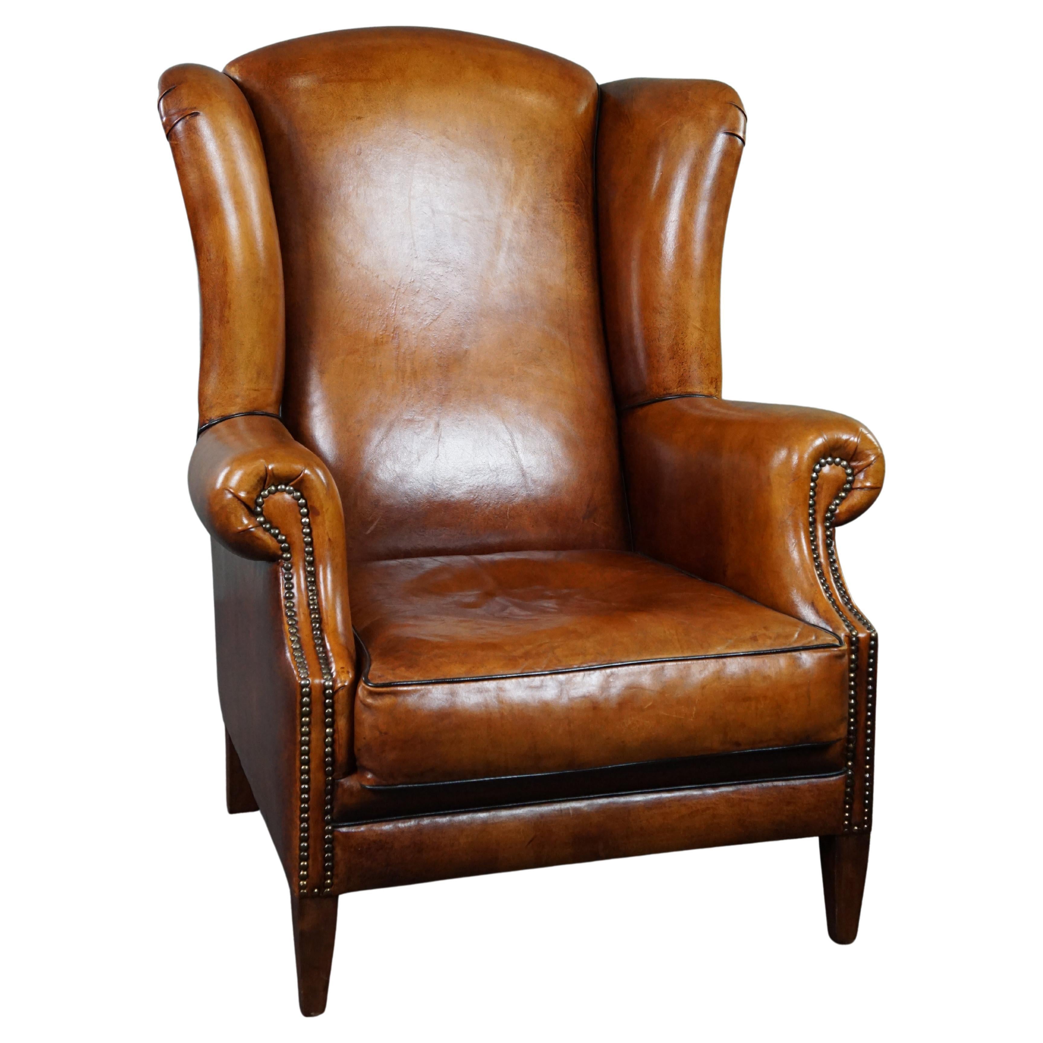 Sheepskin wingback chair with black piping For Sale