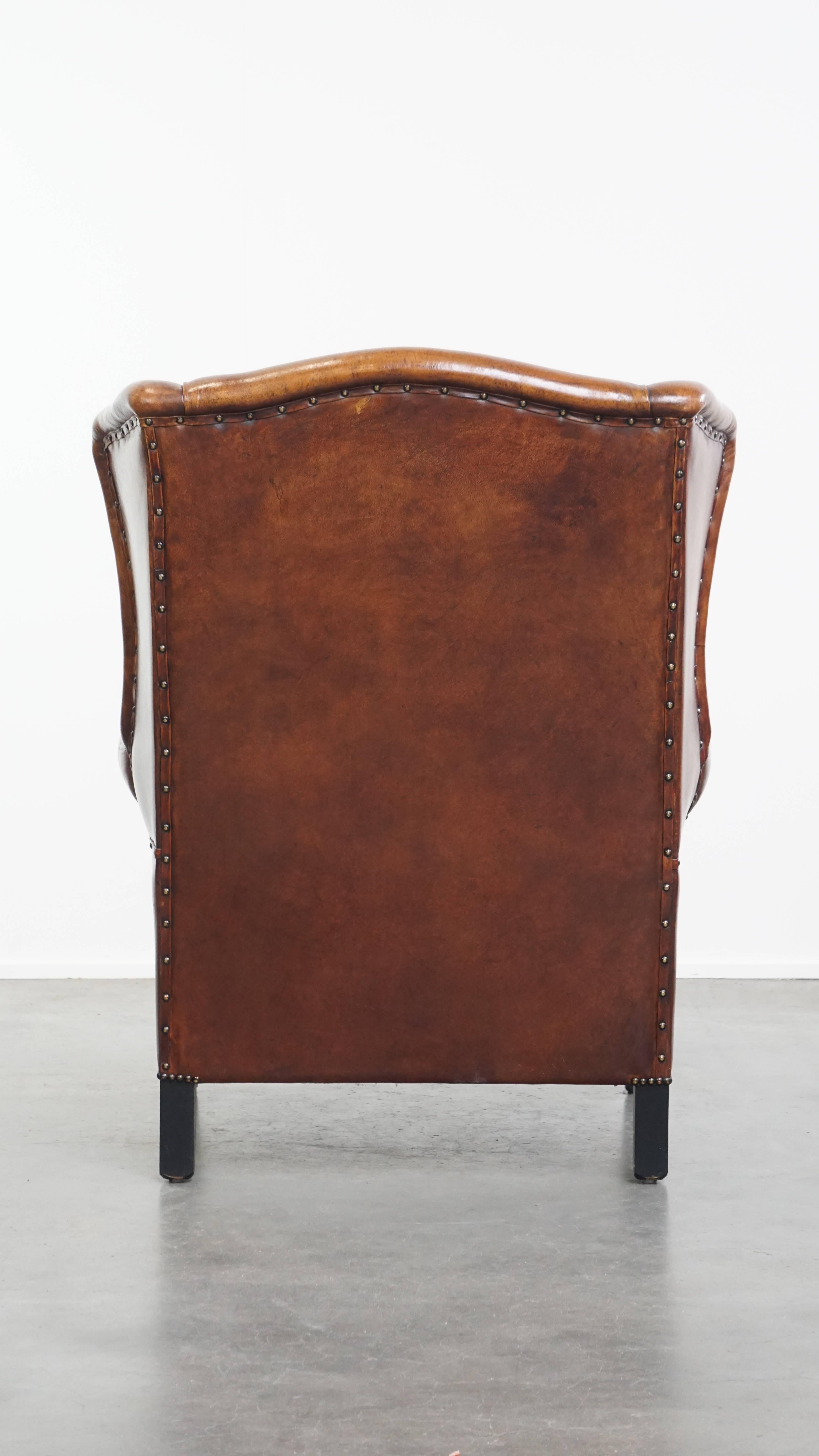 Silla Wingback de piel de oveja con tonos cálidos y ribetes negros Hecho a mano en venta