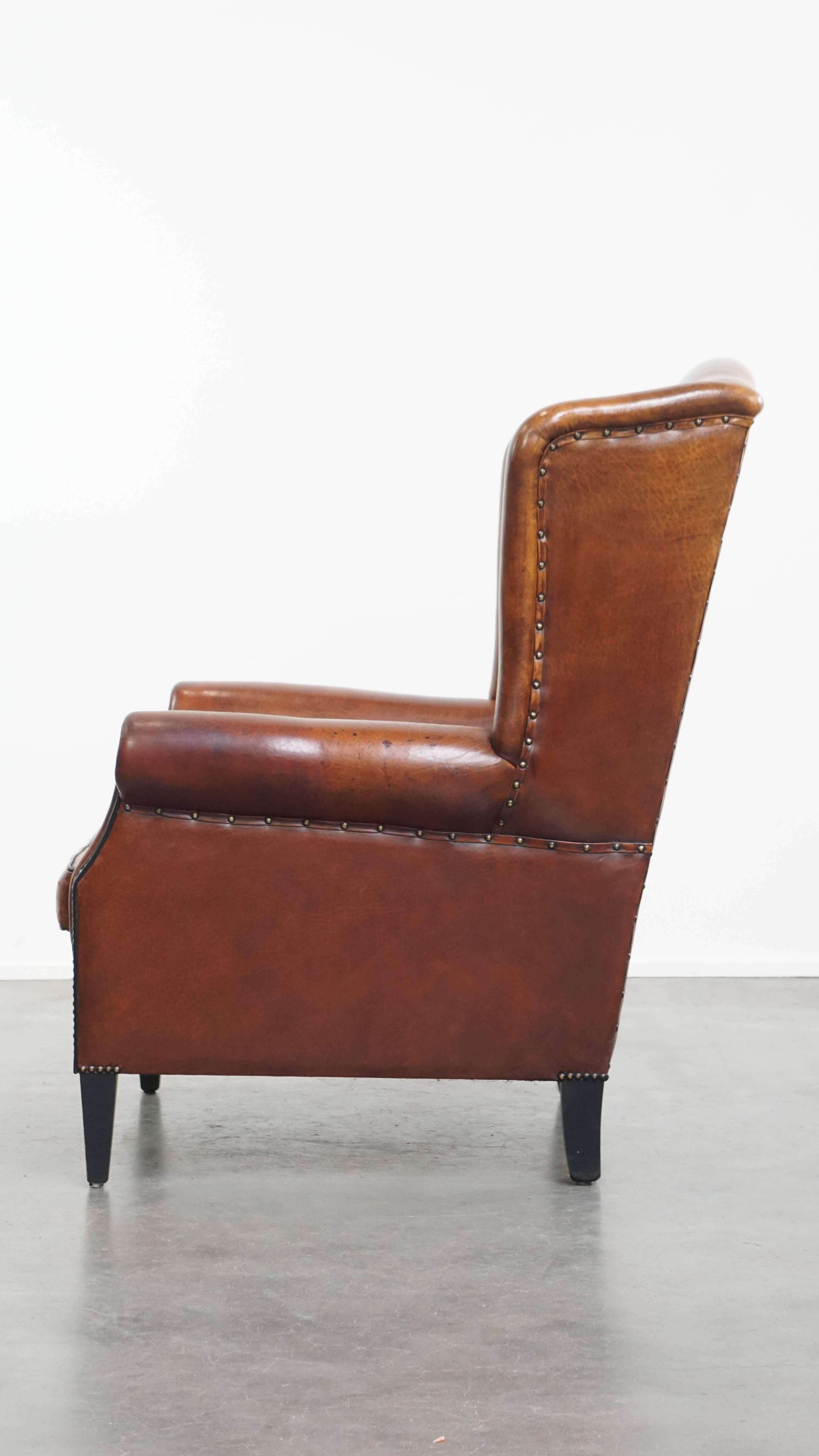 Silla Wingback de piel de oveja con tonos cálidos y ribetes negros en Bueno estado para la venta en Harderwijk, NL