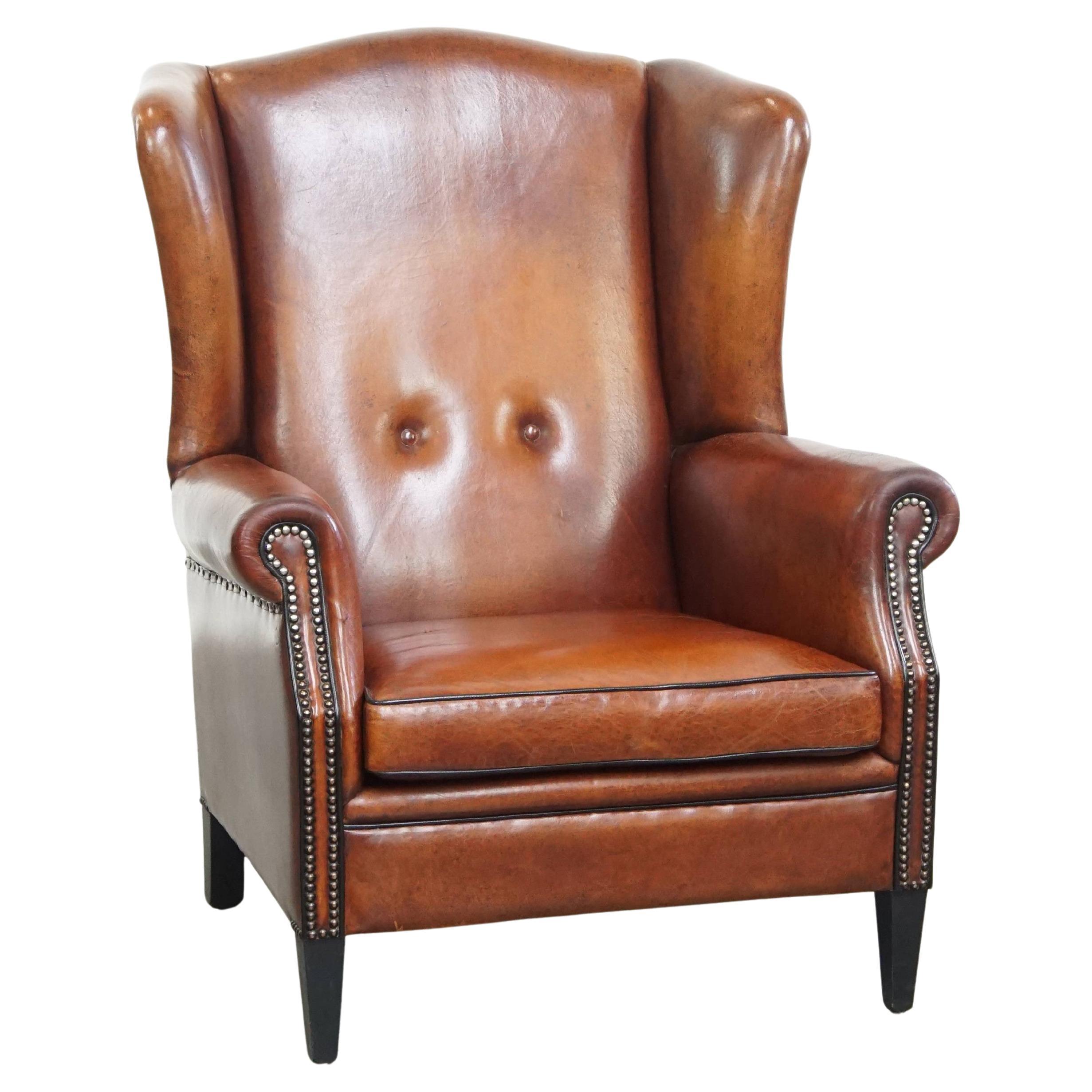 Silla Wingback de piel de oveja con tonos cálidos y ribetes negros en venta
