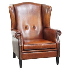 Silla Wingback de piel de oveja con tonos cálidos y ribetes negros