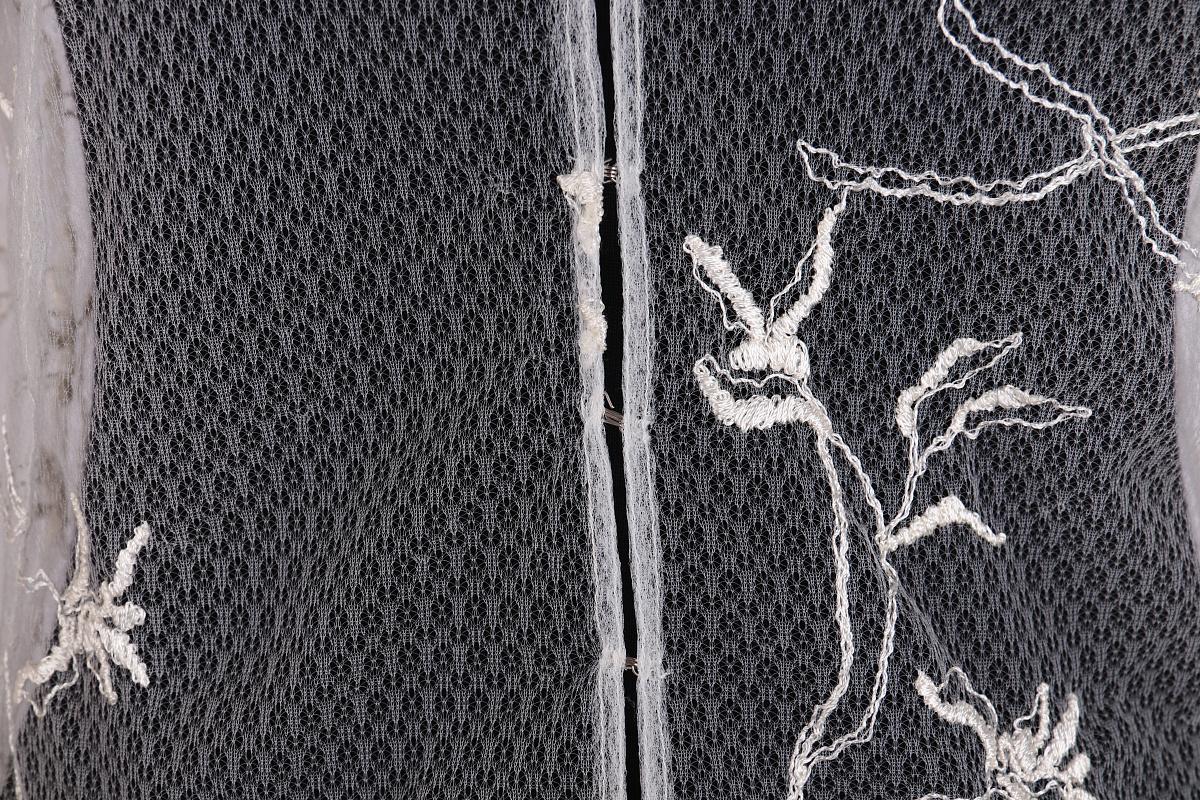 Durchsichtige Bluse von Gianni Versace.

Beschreibung: Diese Bluse ist aus weißem Netzgewebe mit Blumenstickerei gefertigt.
Einzelheiten: Die Bluse hat lange Manschettenärmel und einen Umlegekragen. Der Verschluss ist auf der Vorderseite