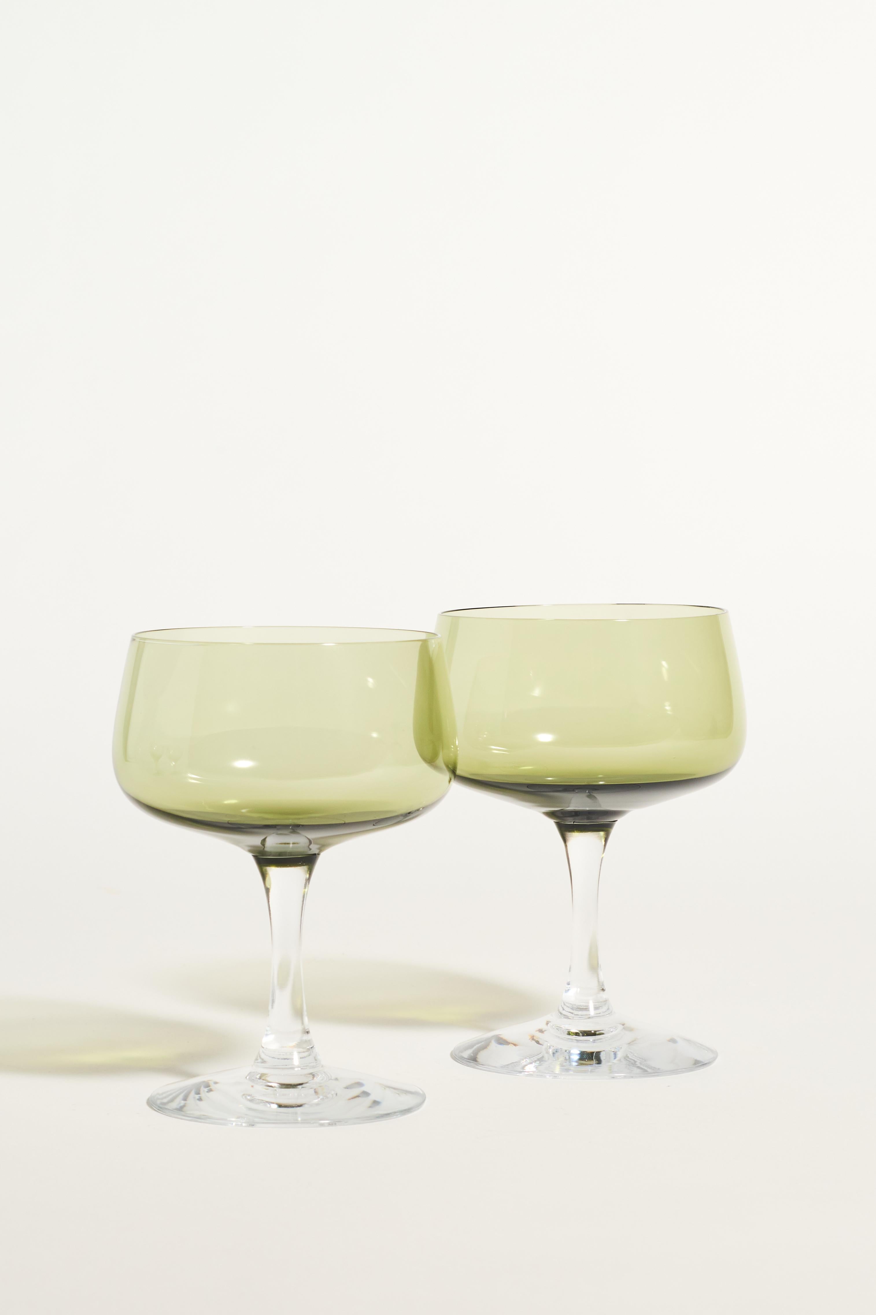 Set of two sheer green cocktail glasses with clear tapered stems.