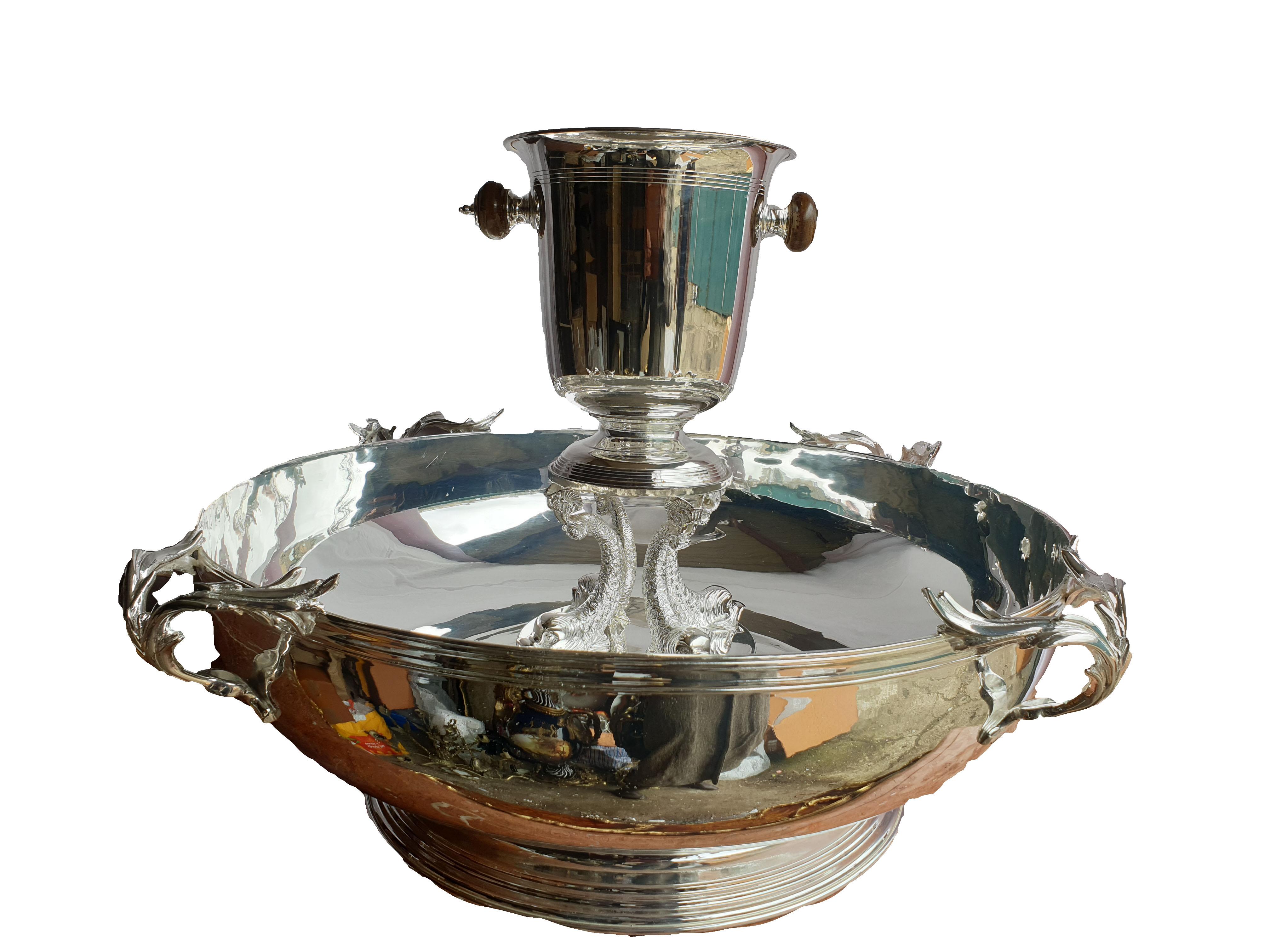 A monumental Sheffield made 12 bottle silver plated champagne cooler. Decorated with branches as handles and a ribbed bottom, mounted with a fish central piece and an additional ice bucket on top. Golden medallion can be engraved and stuck on the