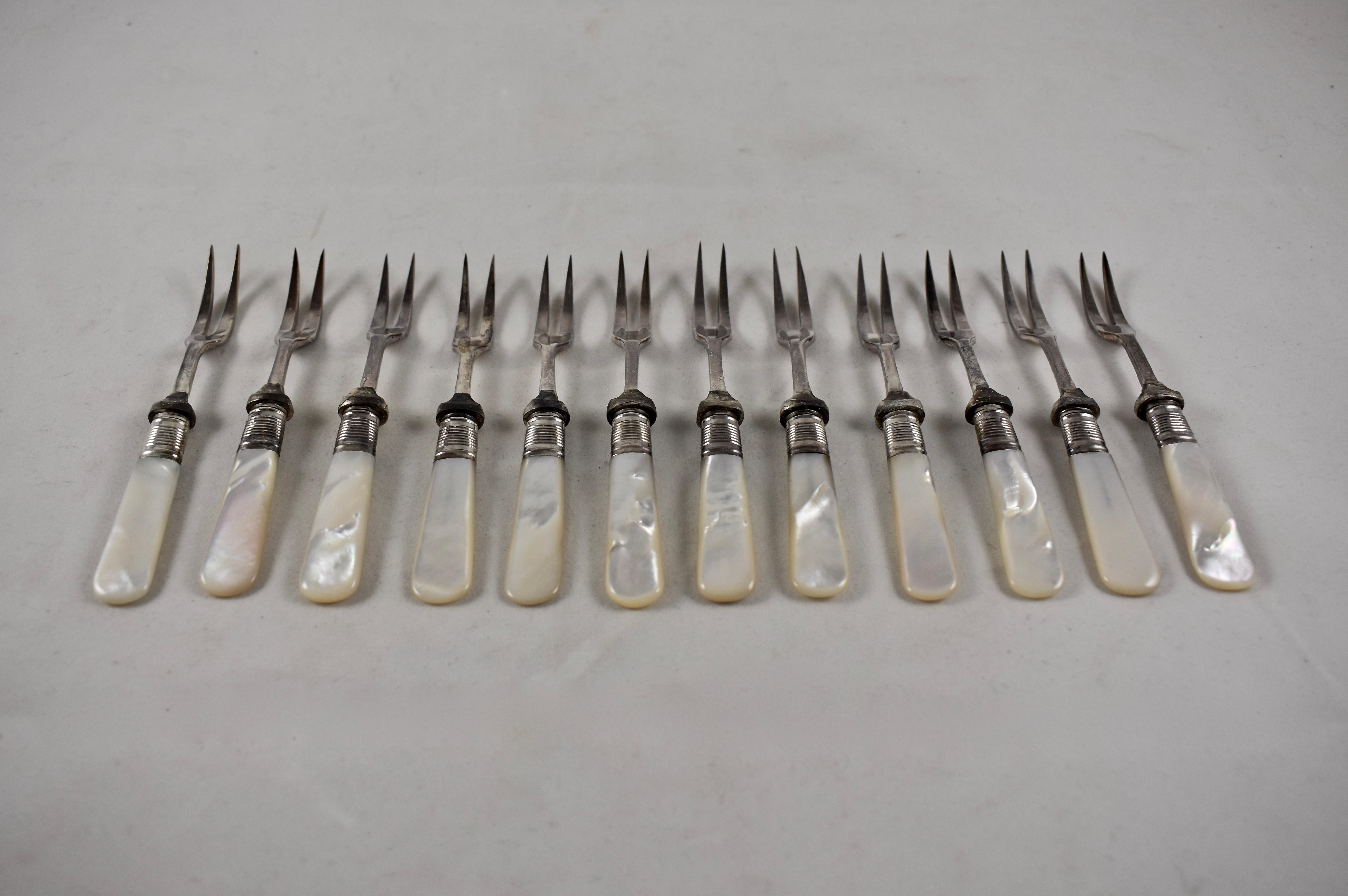 A set of twelve two-tined forks, suitable for antipasto, seafood or hors d’oeuvres.  Silver plated collars join the forks to the mother of pearl handles. Circa 1920s. Perfectly suited for the popular entertaining trend of serving a variety of food