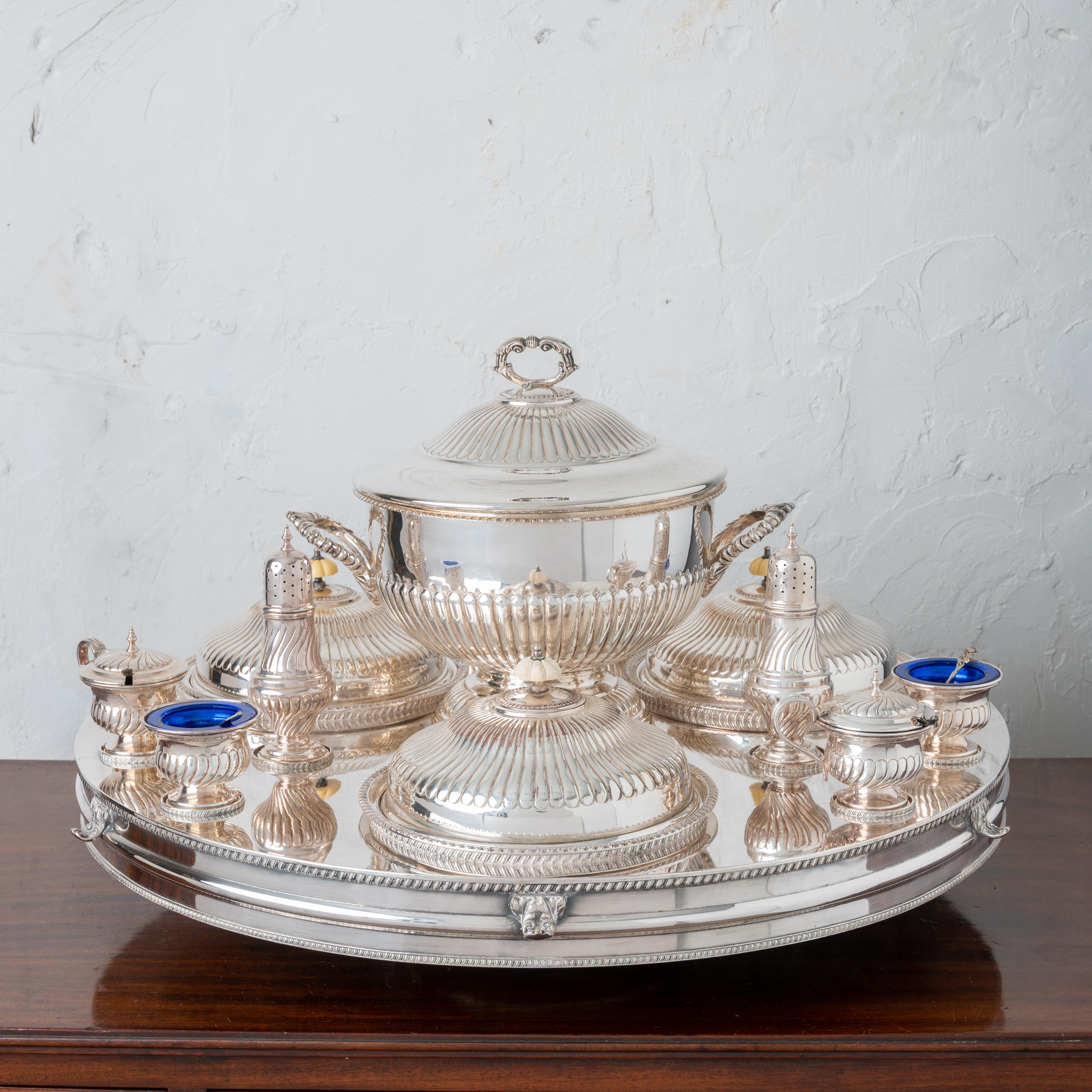 A Sheffield silverplate lazy susan server, circa 1920s

Edwardian style with large hot water tank base on heavy pedestal with thumb holds for turning.  A large lidded tureen in the center surrounded by three covered warming dishes submerged into
