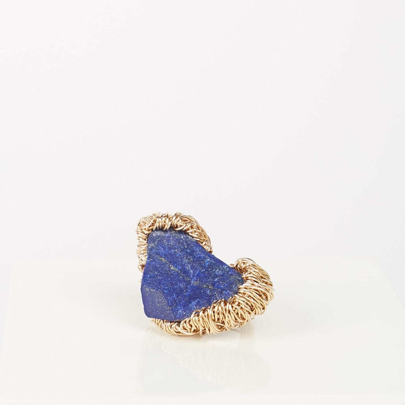 Sheila Westera's Liberty Ring is a gorgeous combination of 14k Gold and rough Lapis Lazuli. 

The Liberty Ring features her signature wire-work technique.  Using 14k yellow gold wire, she weaves to encircle rough stones in 'nests'. 

An utterly