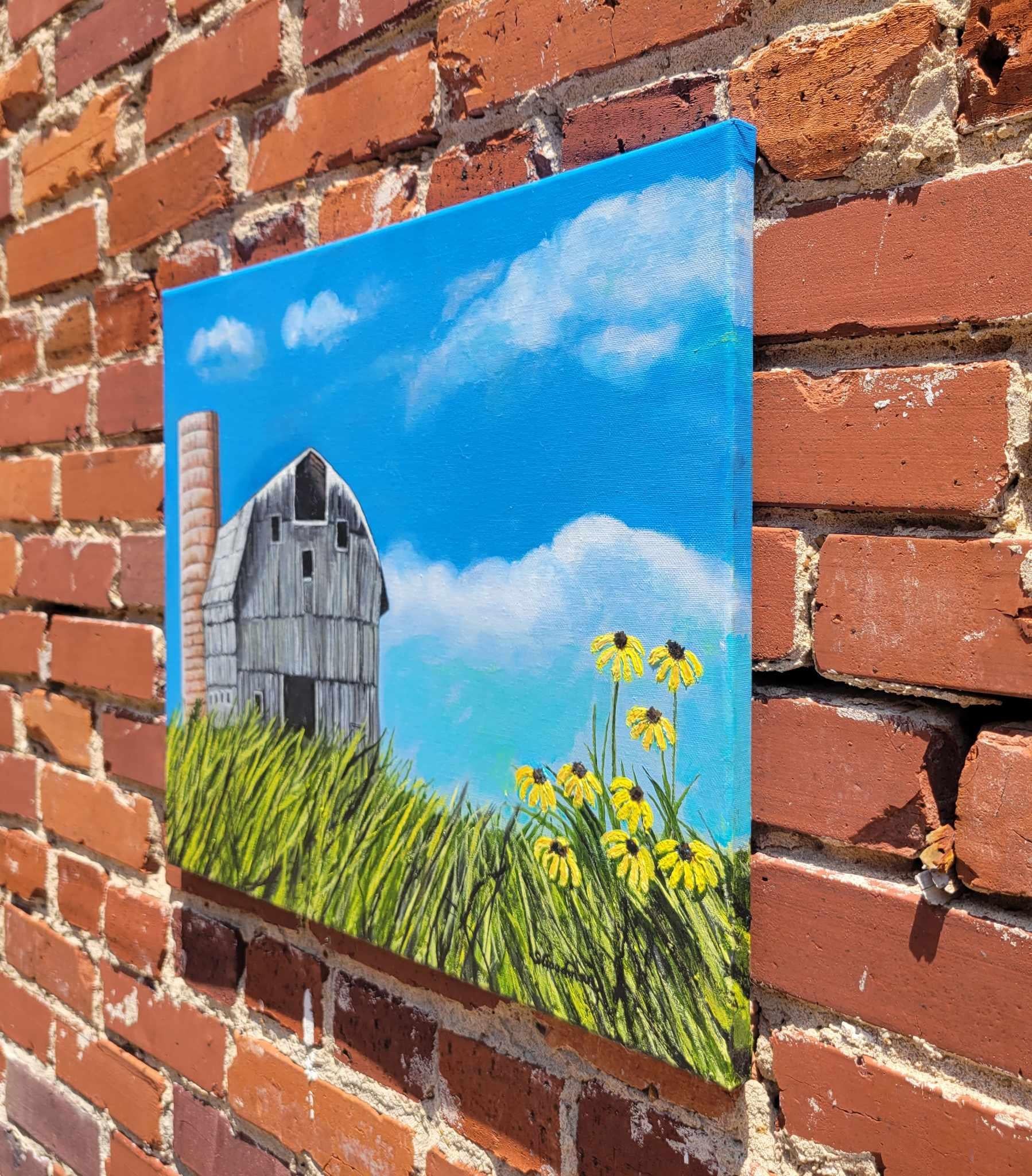 <p>Artist Comments<br>Artist Shela Goodman presents an impressionist outlook of a barn and silo. The placement of the yellow flowers in the foreground aptly embodies the carefree stillness only the countryside can offer. 