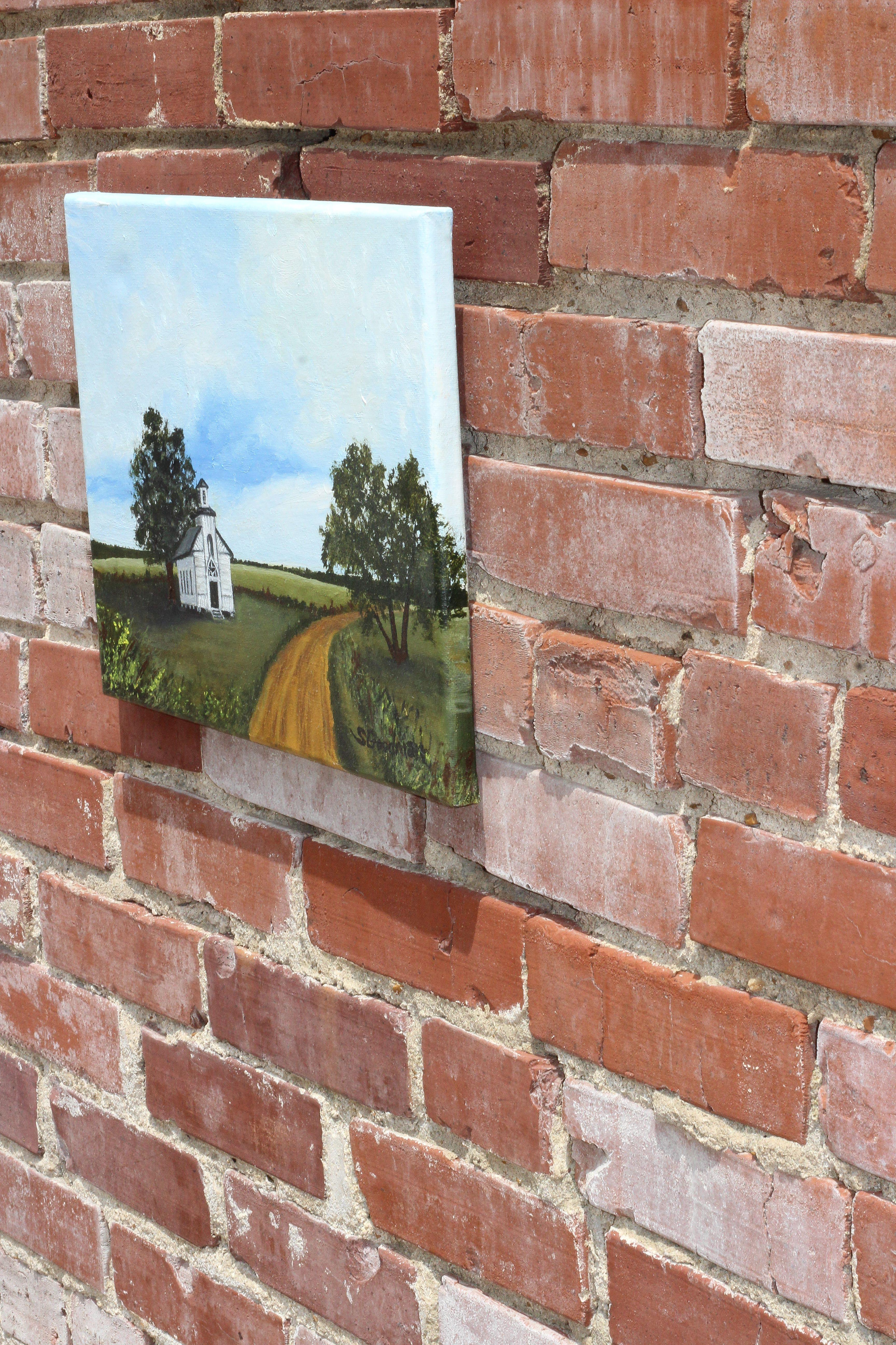 <p>Artist Comments<br>Artist Shela Goodman paints an old country church on an quiet landscape. It sits alone surrounded by fields that seem to be deserted. 