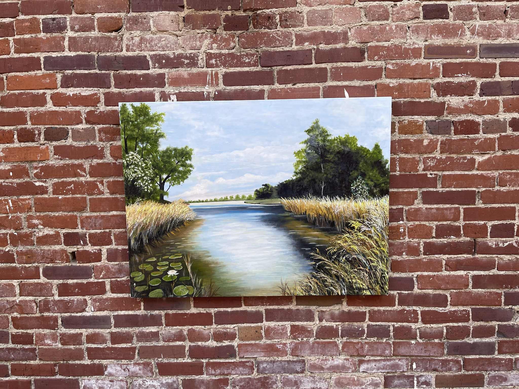 <p>Artist Comments<br>A river scene unfolds with quiet vitality, alive with hidden movement. Frogs, bugs, fish, and tadpoles hide above and below the water's surface. Reeds and water lilies gather at the edges, framing the stillness with natural