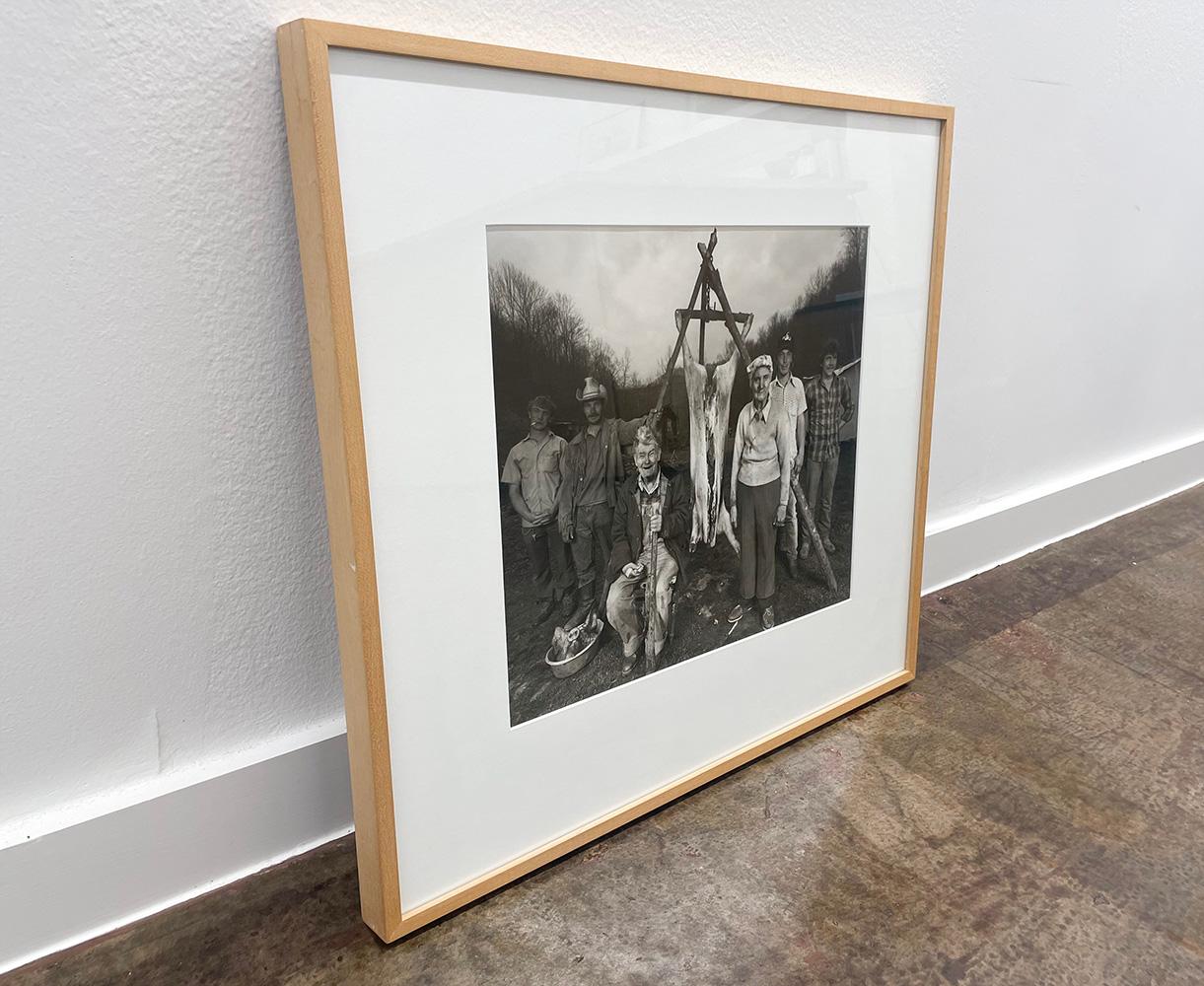 Hog Killing by Shelby Lee Adams is a black and white photograph of as Appalachian family posing around freshly killed pig, in the process of cleaning the animal to later be eaten.

Gelatin Silver Print
16 x 20 in.
Signed, titled, dated and numbered