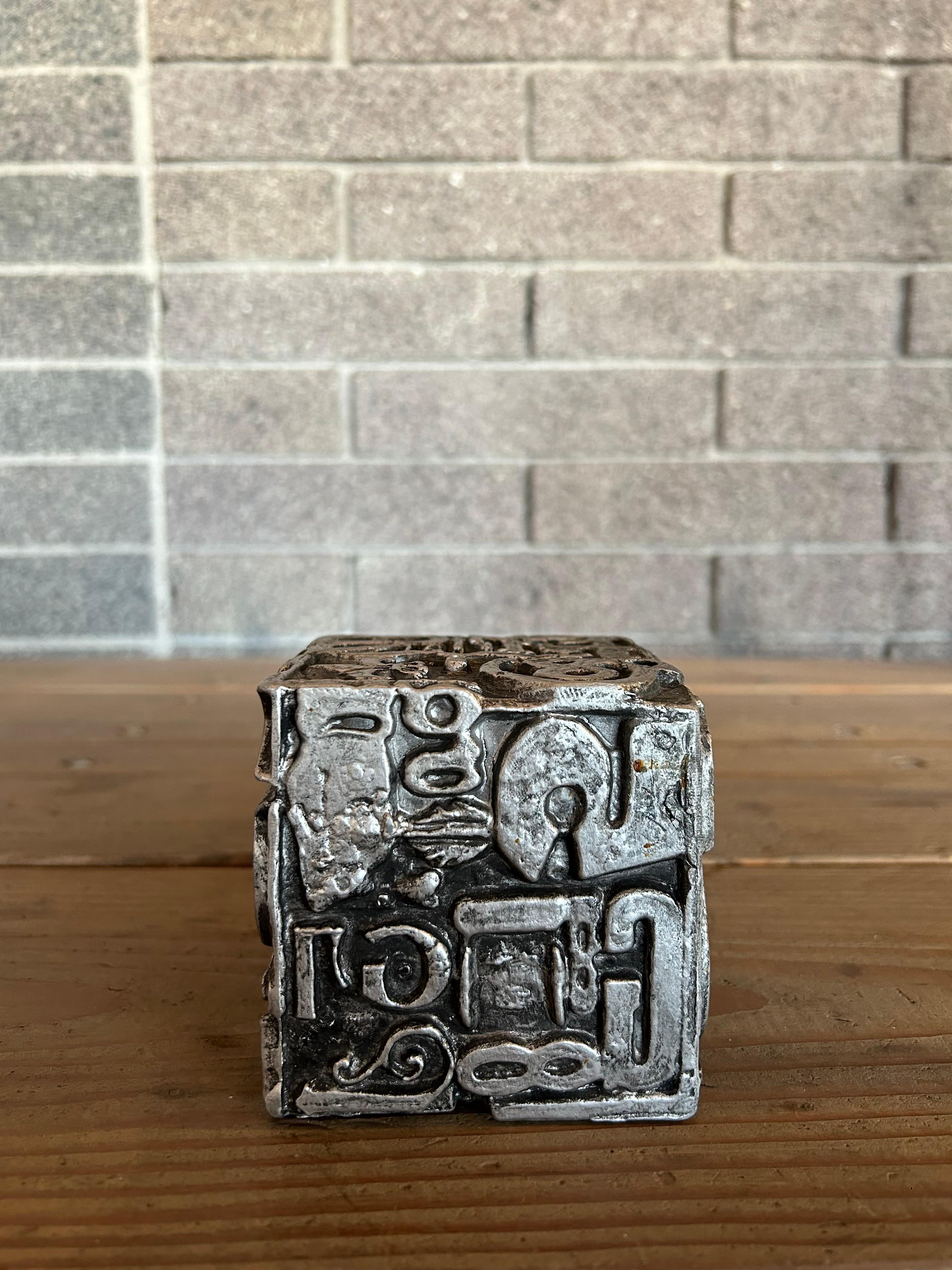 Decorative 1970s MCM cube sculpture in aluminum adorned with text, lettering and graphic design by artist Sheldon Rose. 