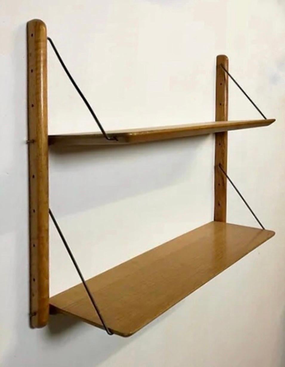 Vintage shelf by Jacques Hauville for BEMA from the 1950s. Featuring two shelves in golden oak and two solid oak supports. Brass support rods. Well-preserved condition.