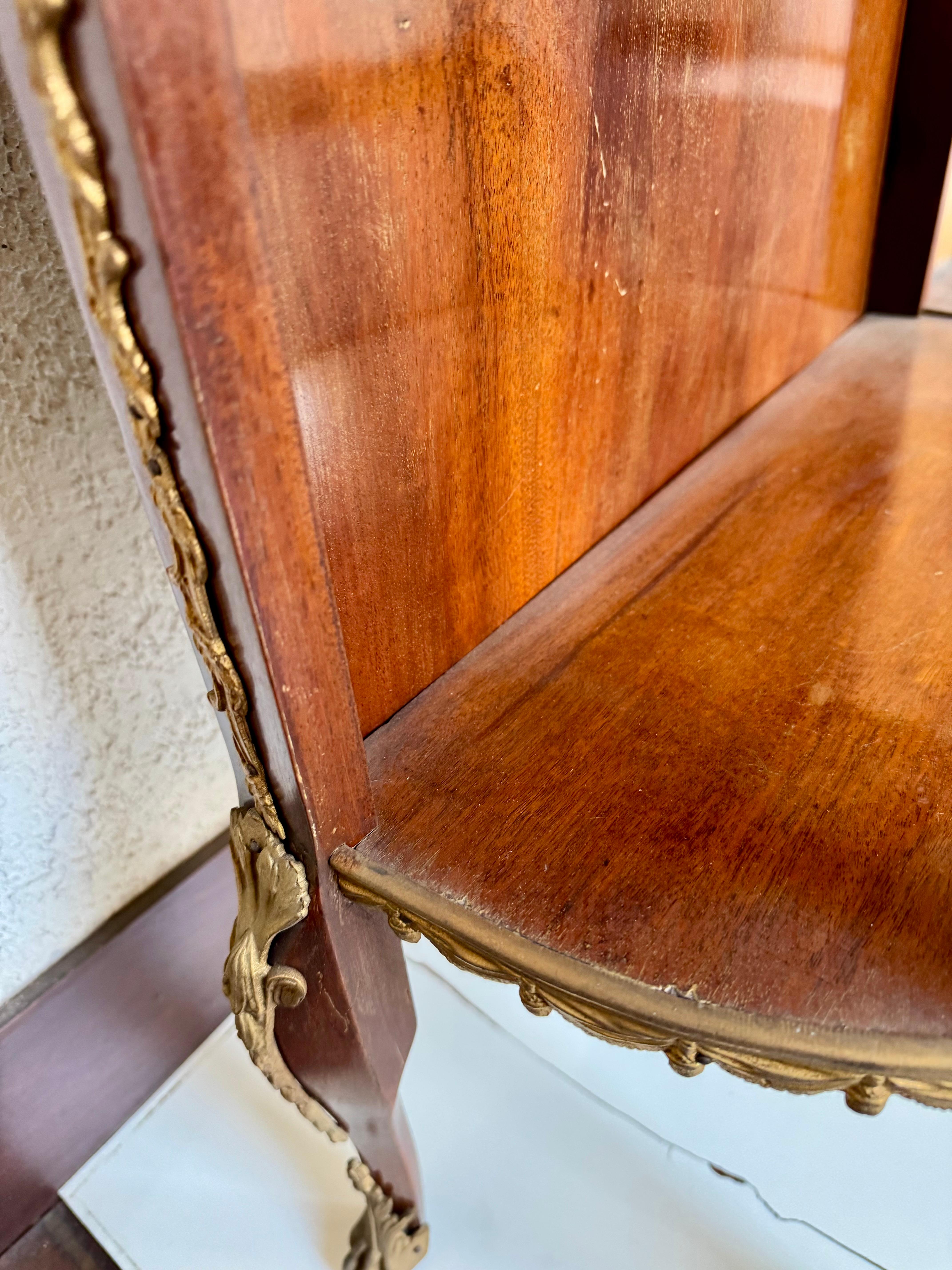 Bellissima mensola in mogano e bronzo, in stile Luigi XVI. Ogni ripiano è rifinito con una cintura di bronzo, la parte superiore è circondata da una galleria di bronzo traforata all'interno della quale è incastonato un bel marmo. 