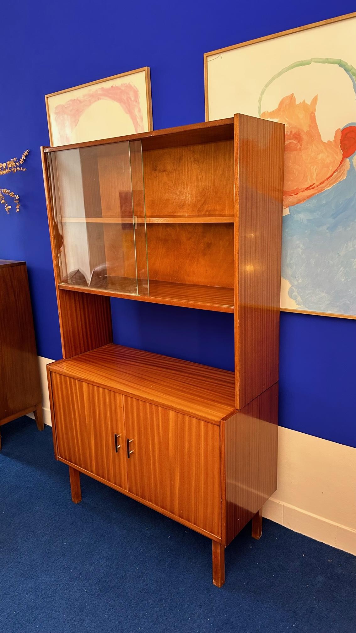 Small enfilade topped by a glass cabinet with two sliding glass doors. Nice design offering a good storage. Polish furniture from the 60's. Dimensions: 100 cm long, 42 cm deep, 32 cm for the showcase, 173 cm high.