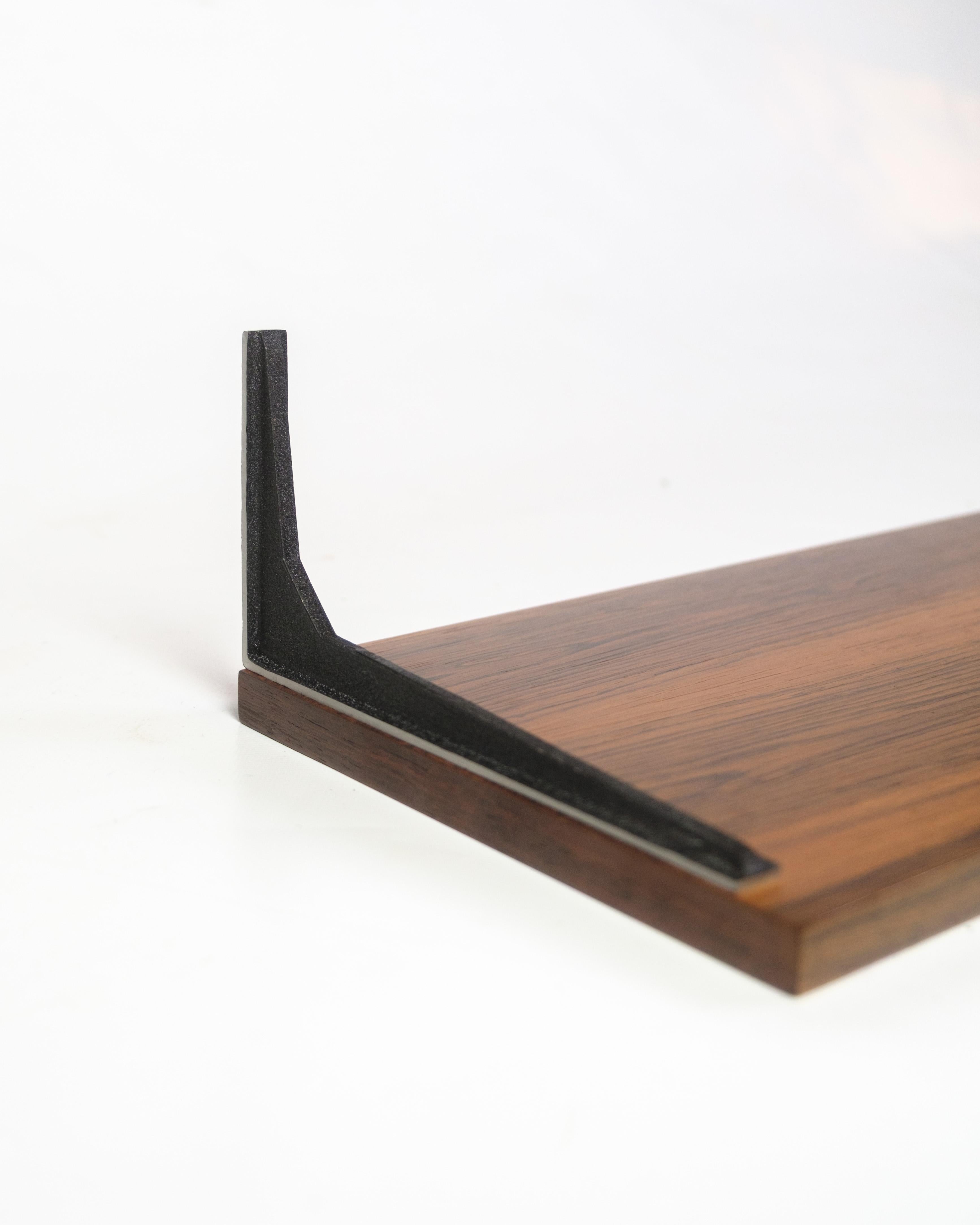 Shelf in rosewood with black lacquered metal suspension, designed by Albert Hansen as part of the Model Excellent series from the 1960s. The distinctive grain patterns and fine proportions make the shelf ideal for both decorative and practical