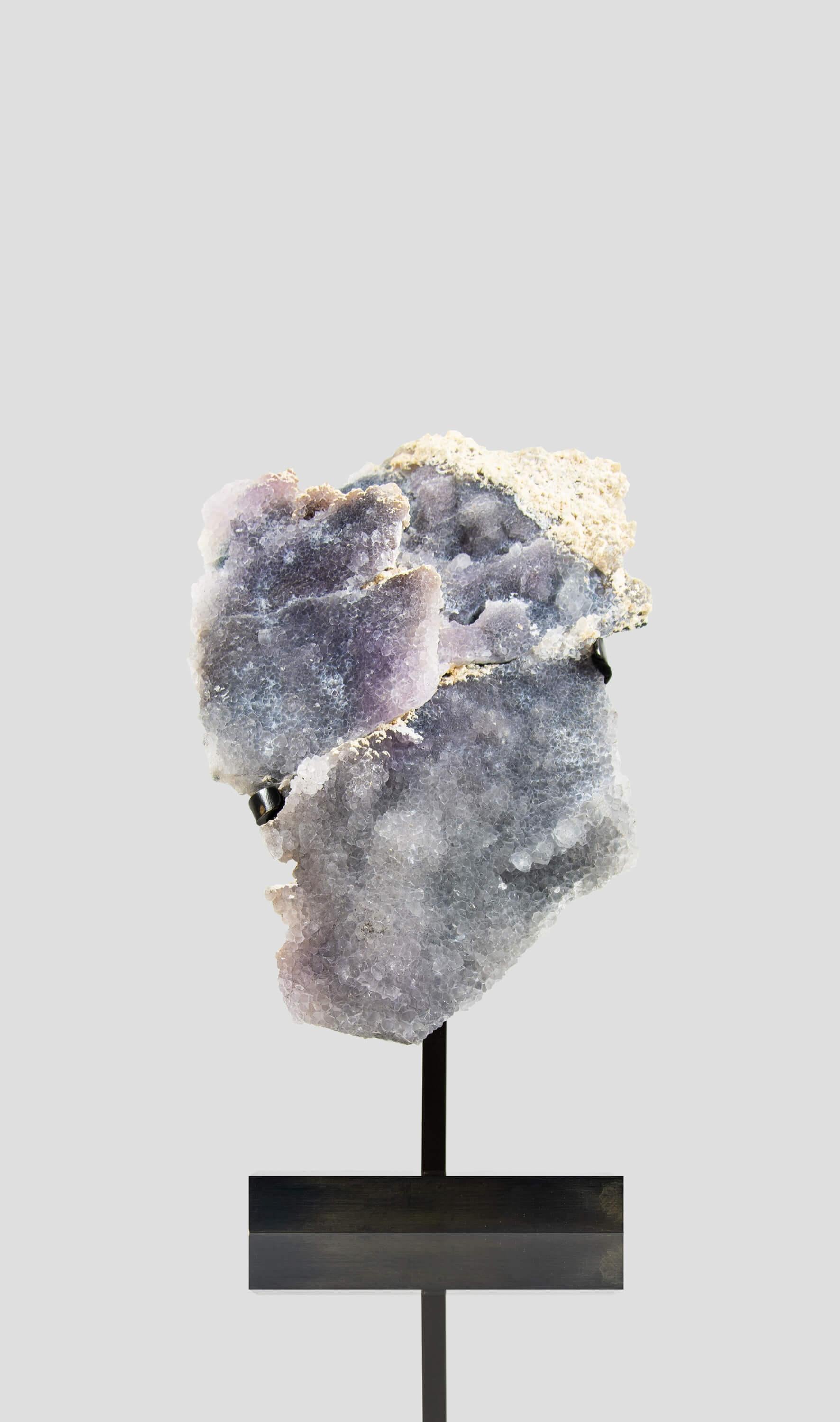La lastra di ametista lavanda che stai considerando è un pezzo unico per la sua struttura e colorazione. La sua delicata tonalità lavanda è rilassante e sofisticata, mentre i grappoli di cristallo druzy aggiungono un tocco di scintillio e curiosità.