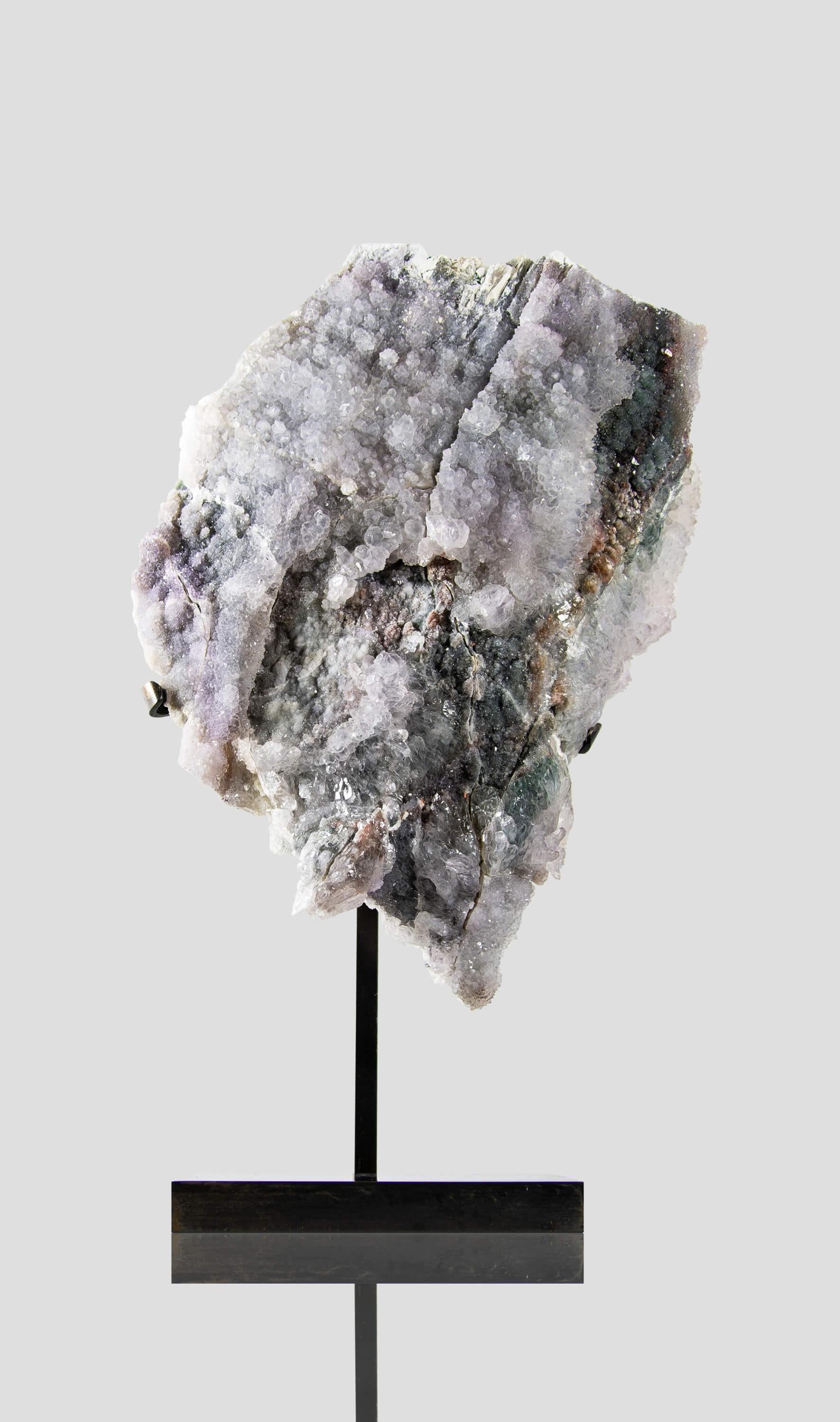 La lastra di ametista lavanda che stai considerando è un pezzo unico per la sua struttura e colorazione. La sua delicata tonalità lavanda è rilassante e sofisticata, mentre i grappoli di cristallo druzy aggiungono un tocco di scintillio e curiosità.