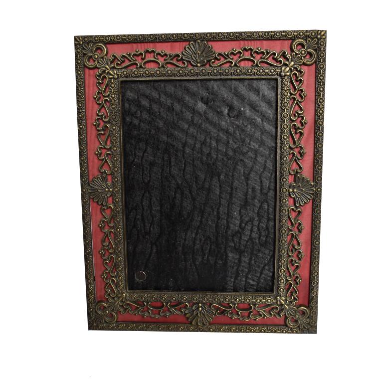 Lovely photo frame created out of pierced metal and backed with a silk maroon fabric. Metal at the front is in a shell motif with flourishes that look like hearts. (A great Valentine's day gift perhaps?)

Velvet enclosure at back with a stand for
