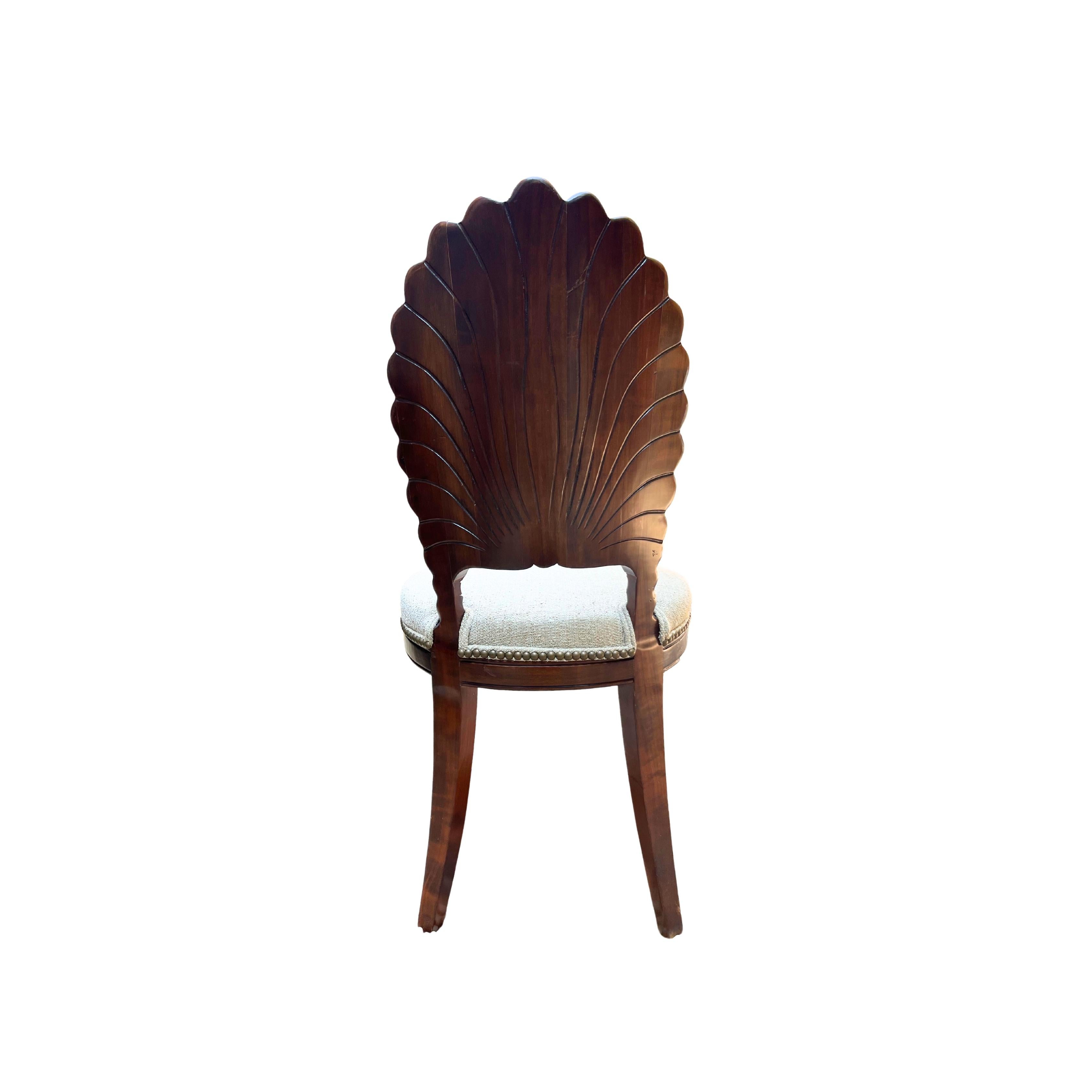 Impeccably hand-carved Grotto-style mahogany shell-back chairs, showcasing exquisite craftsmanship. These chairs offer exceptional comfort, with detailed carving on both the shell pattern and saber legs. The solid wood frames are in excellent