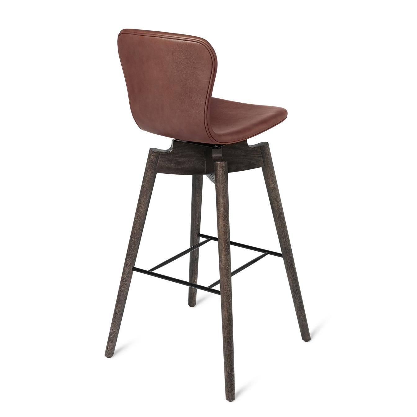 The silhuette of the shell bar stool is elegant and features long lines in solid oak wood and a soft leather backrest swivel-seat in rich and genuine tones and with clean hand tailored stitches.
Together with the most recognised leather supplier in