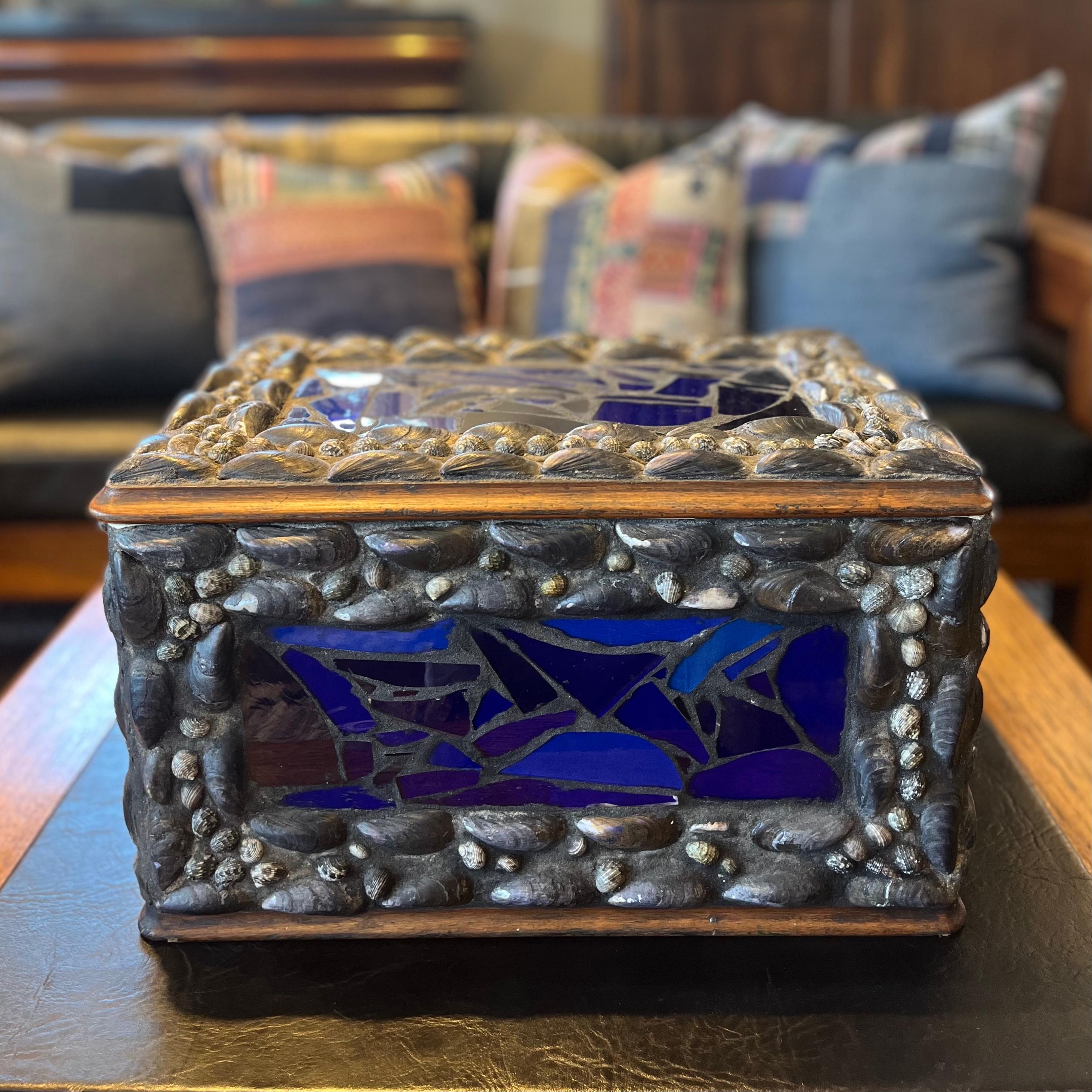 Gorgeous large keepsake box decorated with shards of cobalt blue glass and mussel shells. The piece is lined with collaged images of Modernist paintings, which speaks to the personal, artisanal quality throughout. Sturdy and richly barnacled, the