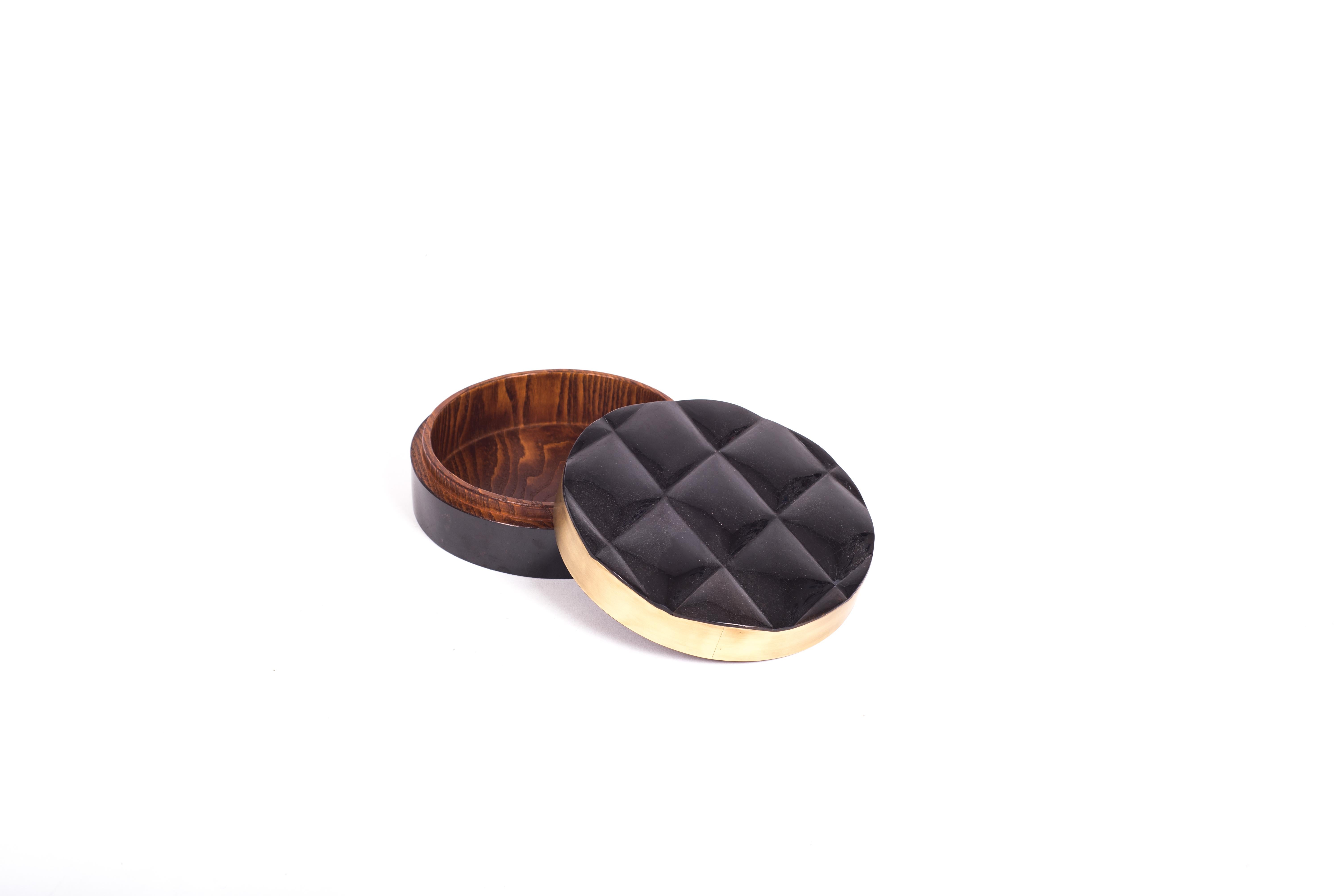 La boîte Coco est une pièce d'accent sophistiquée et luxueuse avec ses détails matelassés exquis. L'extérieur est marqueté en coquille de stylo noir avec un cadre en laiton bronze-patiné et l'intérieur est marqueté en bois de gemelina. Cette annonce