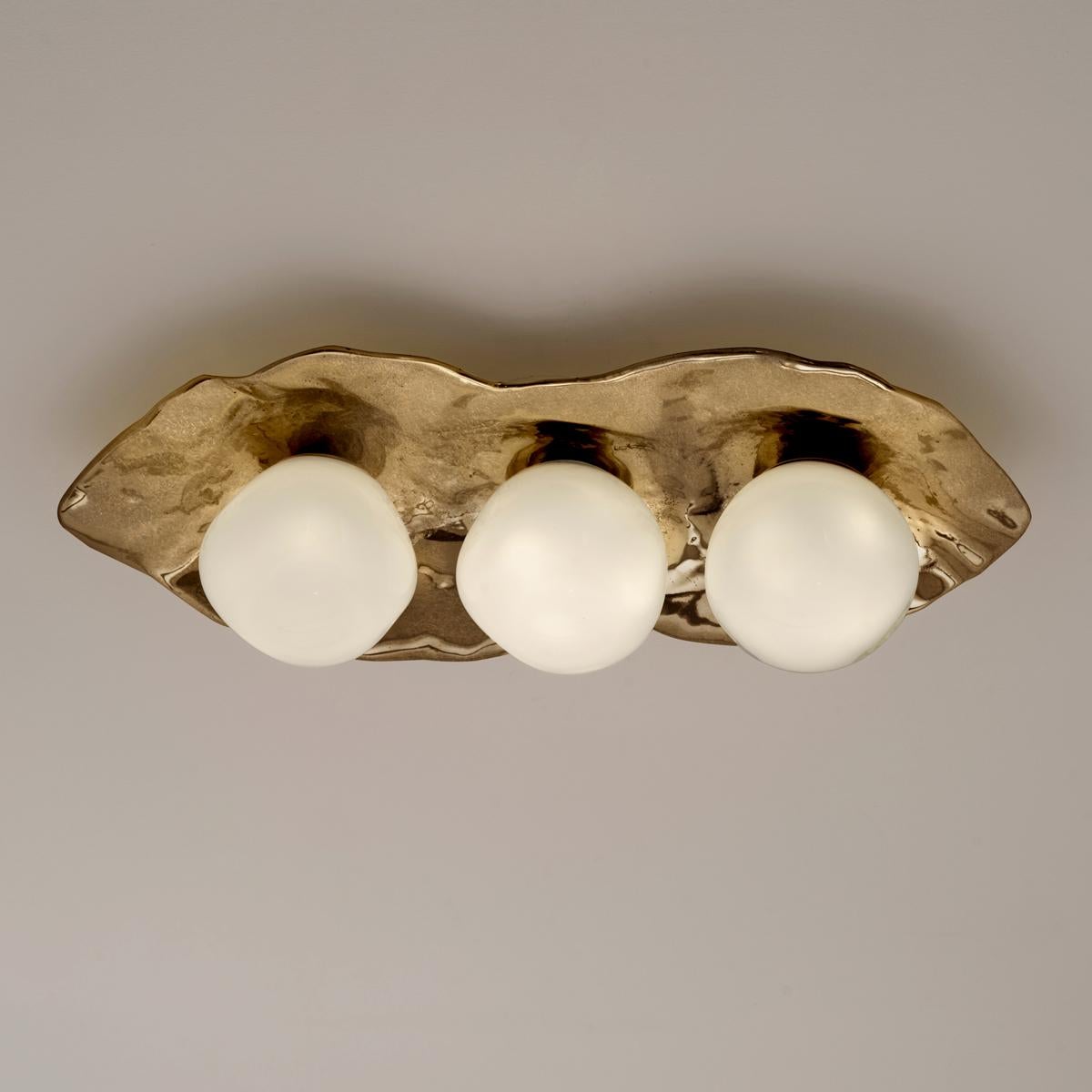 The Shell ceiling light is forged from brass to create an organic shell nestling three of our handblown Sfera glasses made in Murano.

Shown in the primary images in Bronzo Nuvolato-subsequent pictures show the fixture in other featured