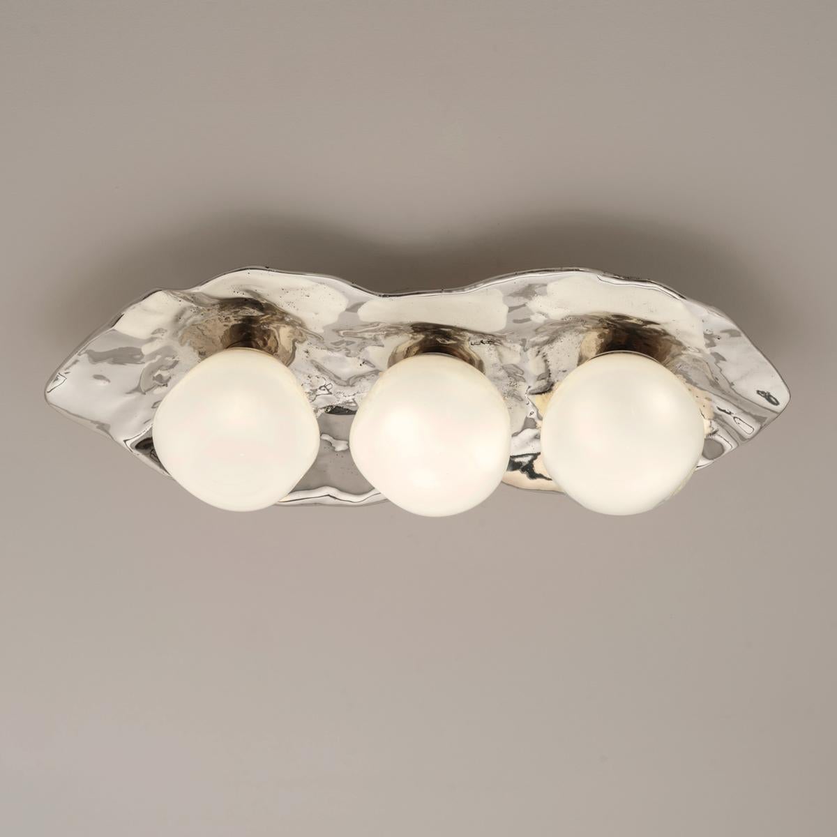 The Shell ceiling light is forged from brass to create an organic shell nestling three of our handblown Sfera glasses made in Murano.

Shown in the primary images in polished nickel-subsequent pictures show the fixture in other featured