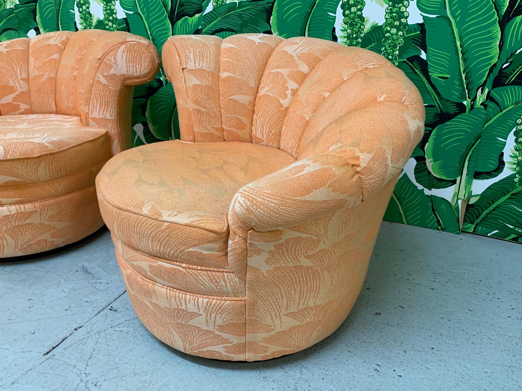 Pair of swivel lounge chairs in asymmetrical nautilus style feature a fan back with tufting and tone-on-tone upholstery and a slight scroll detail on the highest point. Excellent condition overall.