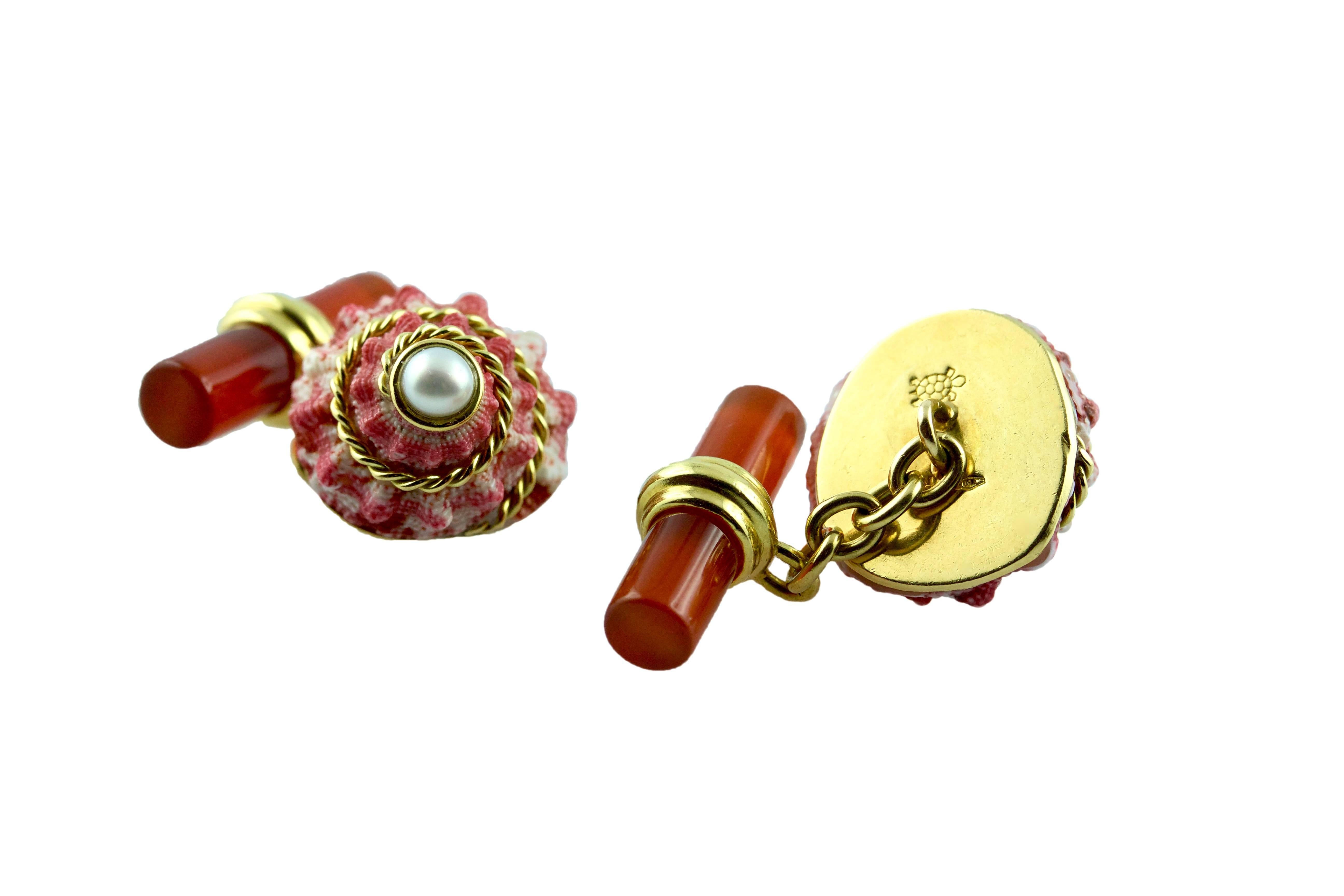 The striking red shade and the white natural texture of this shell, adorned with a pearl at the top and a 18k yellow gold torchon , is the protagonist of the front face of this elegant pair of cufflinks, which also features a cylindrical toggle in