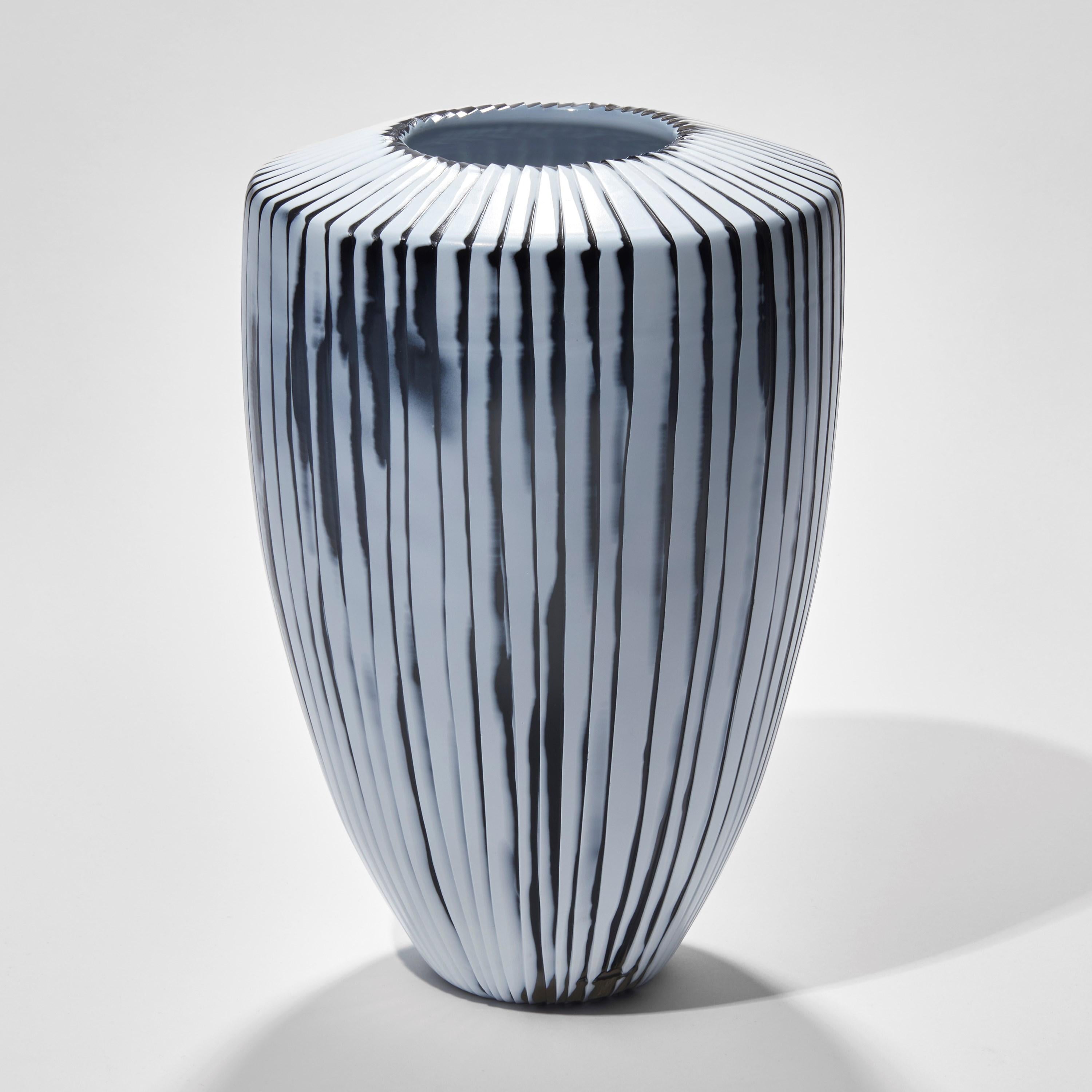 Shell II is a unique white and slate grey handblown and cut glass vase by the British artist Laura Birdsall. A beautifully crafted artwork, after blowing the piece and layering the two colours, it has been cut to create fine ridges, also revealing