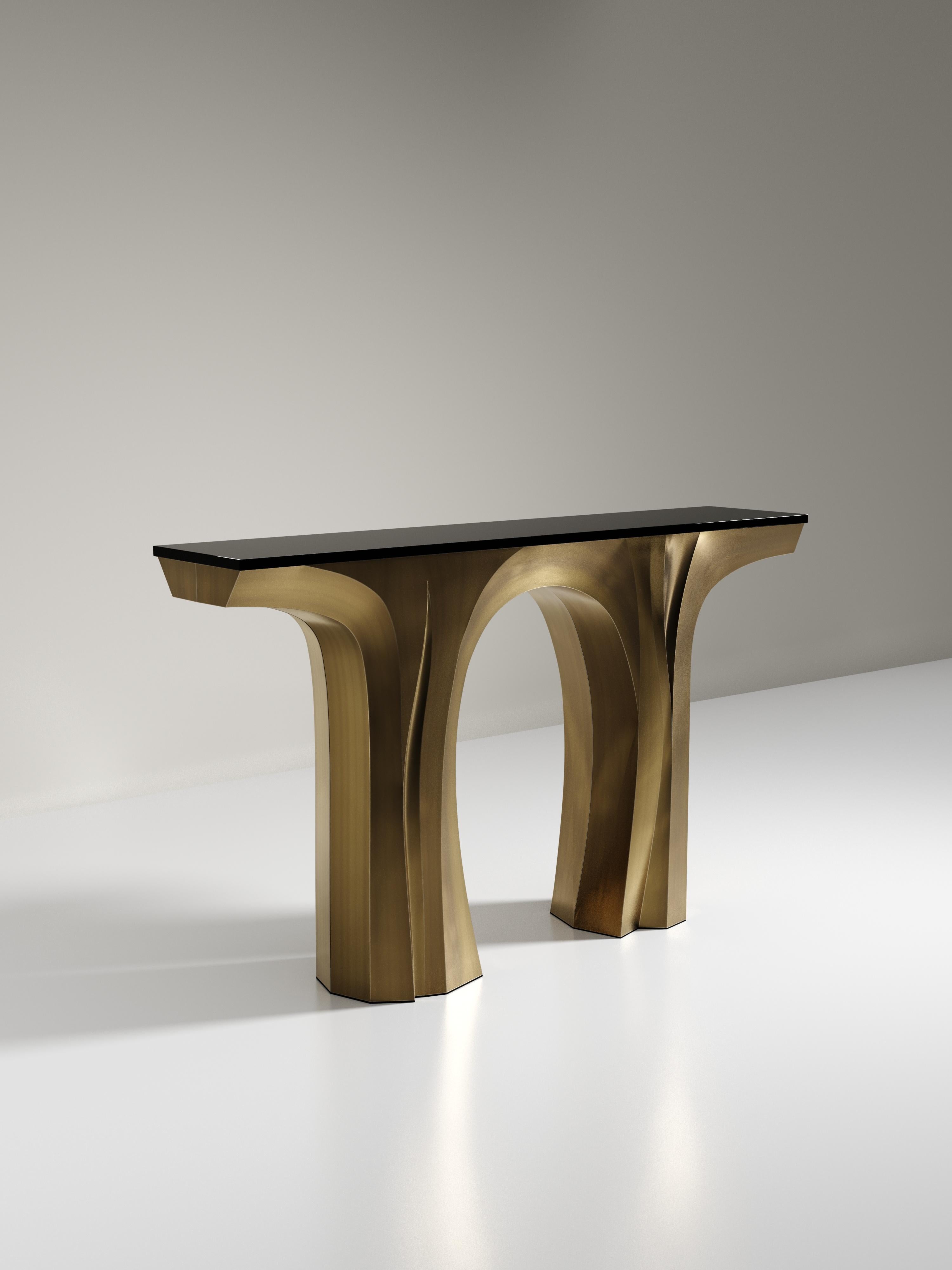 The Alma console by R&Y Augousti is a sculptural and versatile piece. The black pen shell inlaid top morphs into dramatic hand-carved bronze-patina brass legs. The grooves and details on the base allow the console to have different expressions from