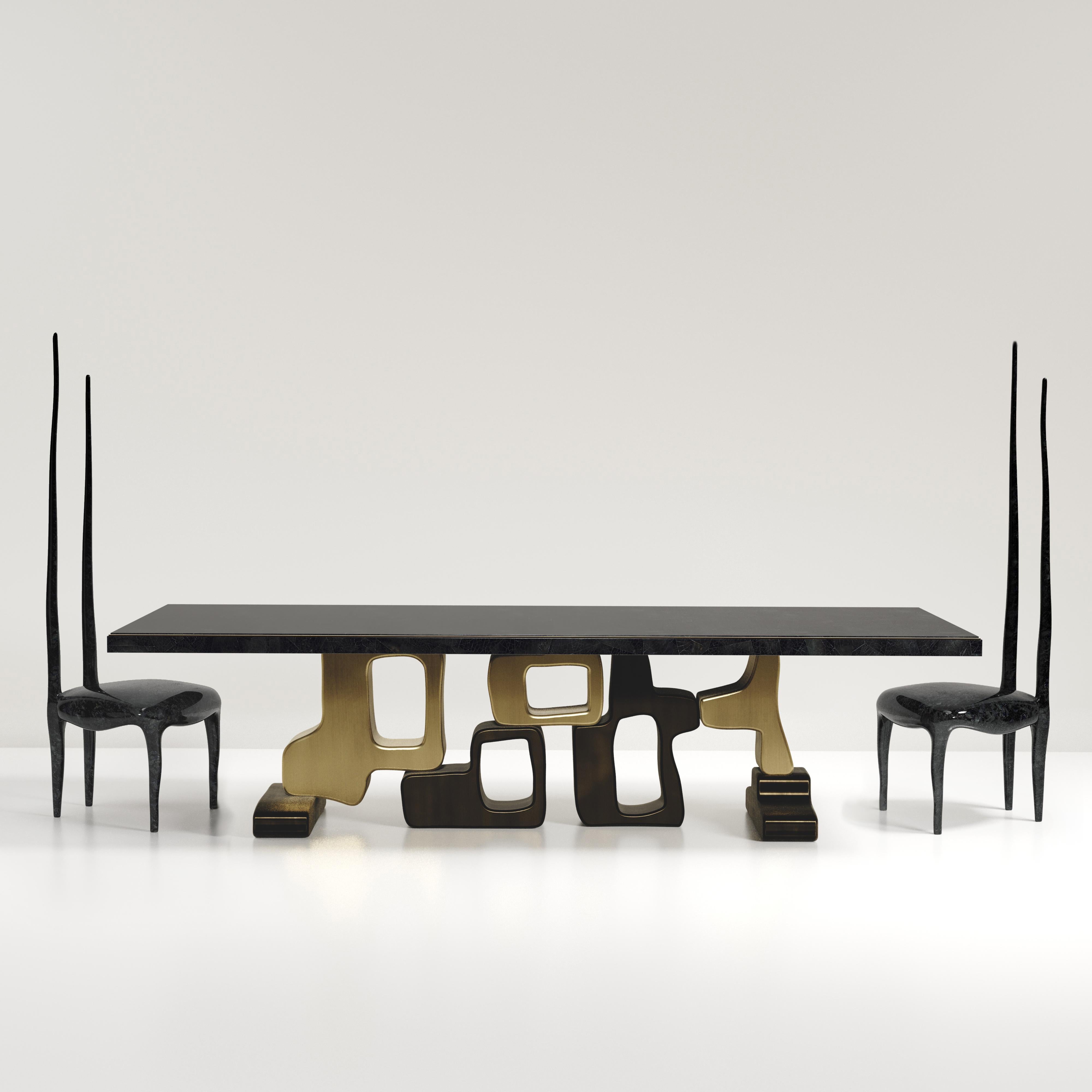 The Apoli II dining table by Kifu Paris is both dramatic and organic its unique design. The black pen shell inlaid top sits on a long clustered geometric and sculptural bronze-patina brass base. This piece is designed by Kifu Augousti the daughter