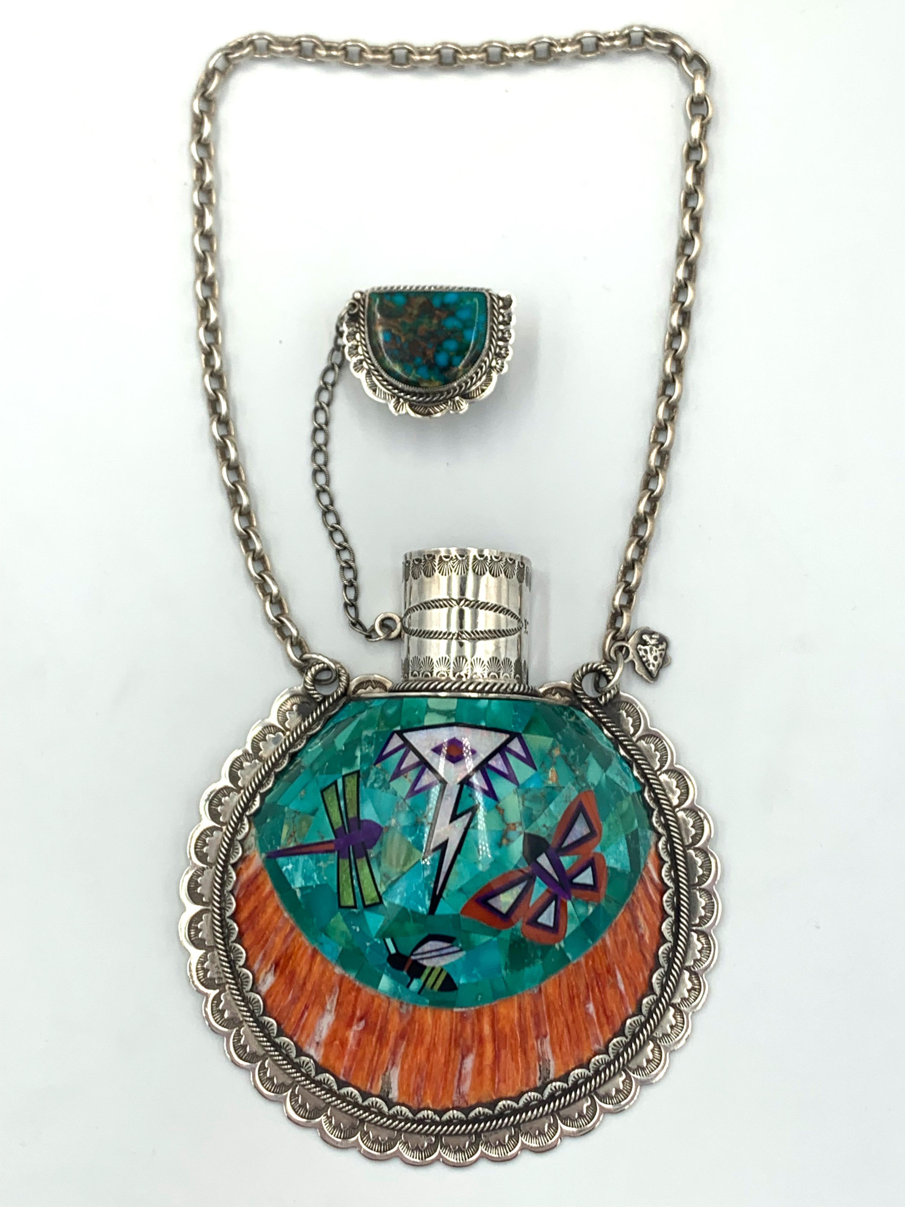 Magnificent sterling silver flask with turquoise and spiny oyster inlay. The 4” x 4 5/8” x 1 1/4” flask has a dragonfly, butterfly, bumblebee, with a stylized cloud and lightening design. Opal, gaspéite, sugilite, and coral are inlaid in the