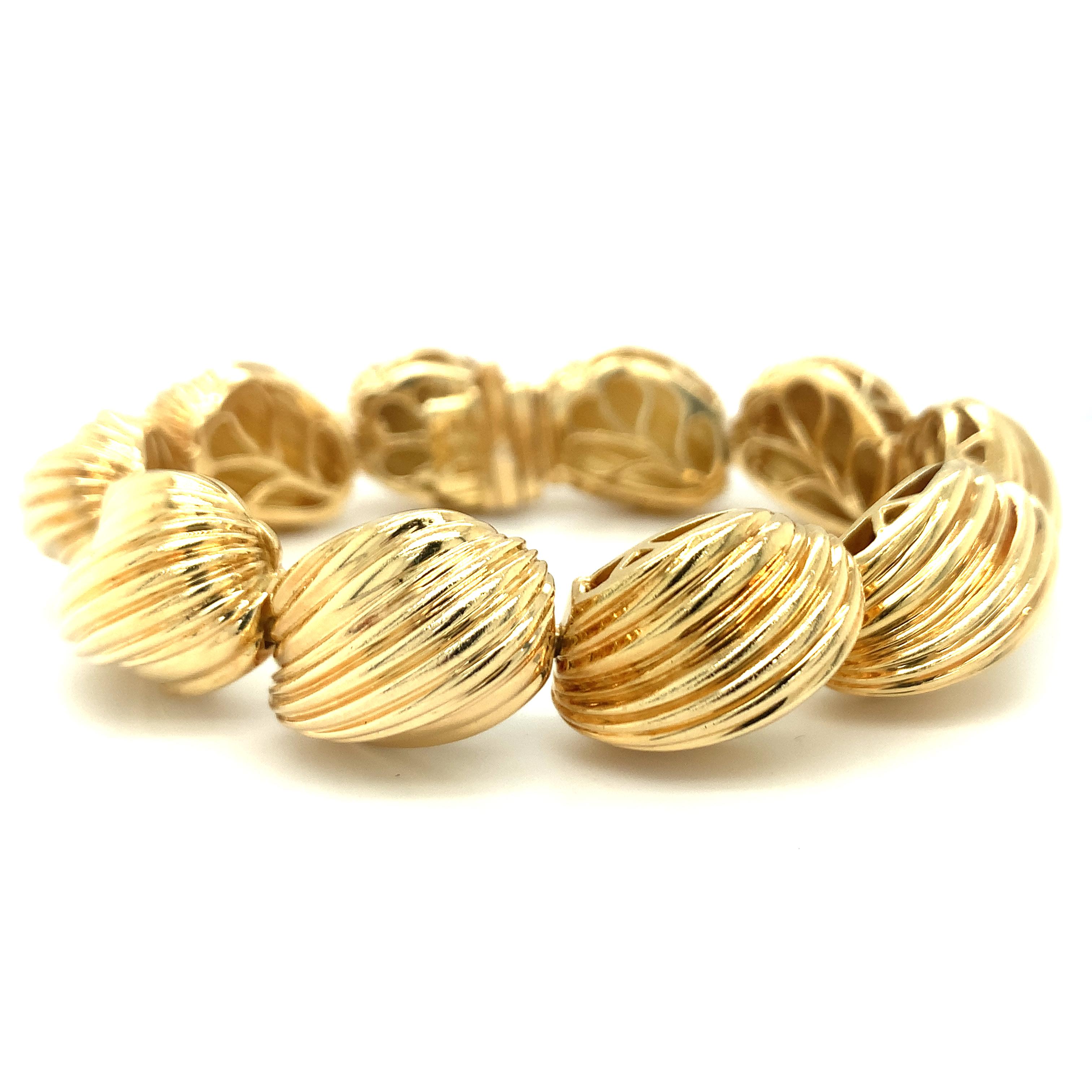 One shell motif link 18K yellow gold bracelet by Hammerman Brothers featuring ten ribbed and high polish gold links measuring 15 mm. wide and 12 mm. tall. Circa 1960s.

Pristine, golden, chic.

Metal: 18K yellow gold
Circa: 1960s
Stamp/Hallmark:
