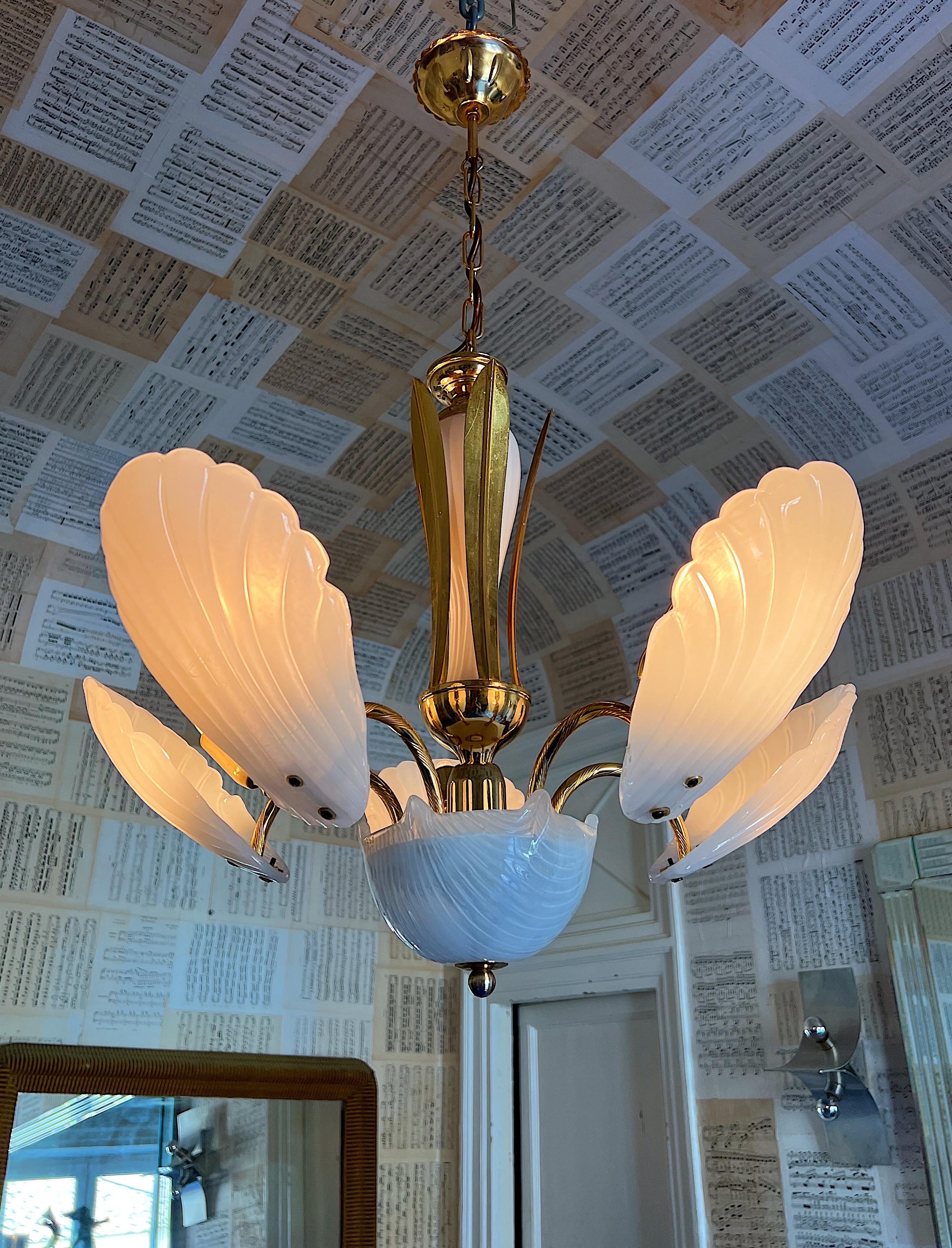 Timeless 1980s Murano Glass Chandelier. Its gold coated structure gracefully supports five arms adorned with magnificent Murano glass shell leaves, creating an exquisite interplay of light and artistry. This chandelier offers an elegant lighting