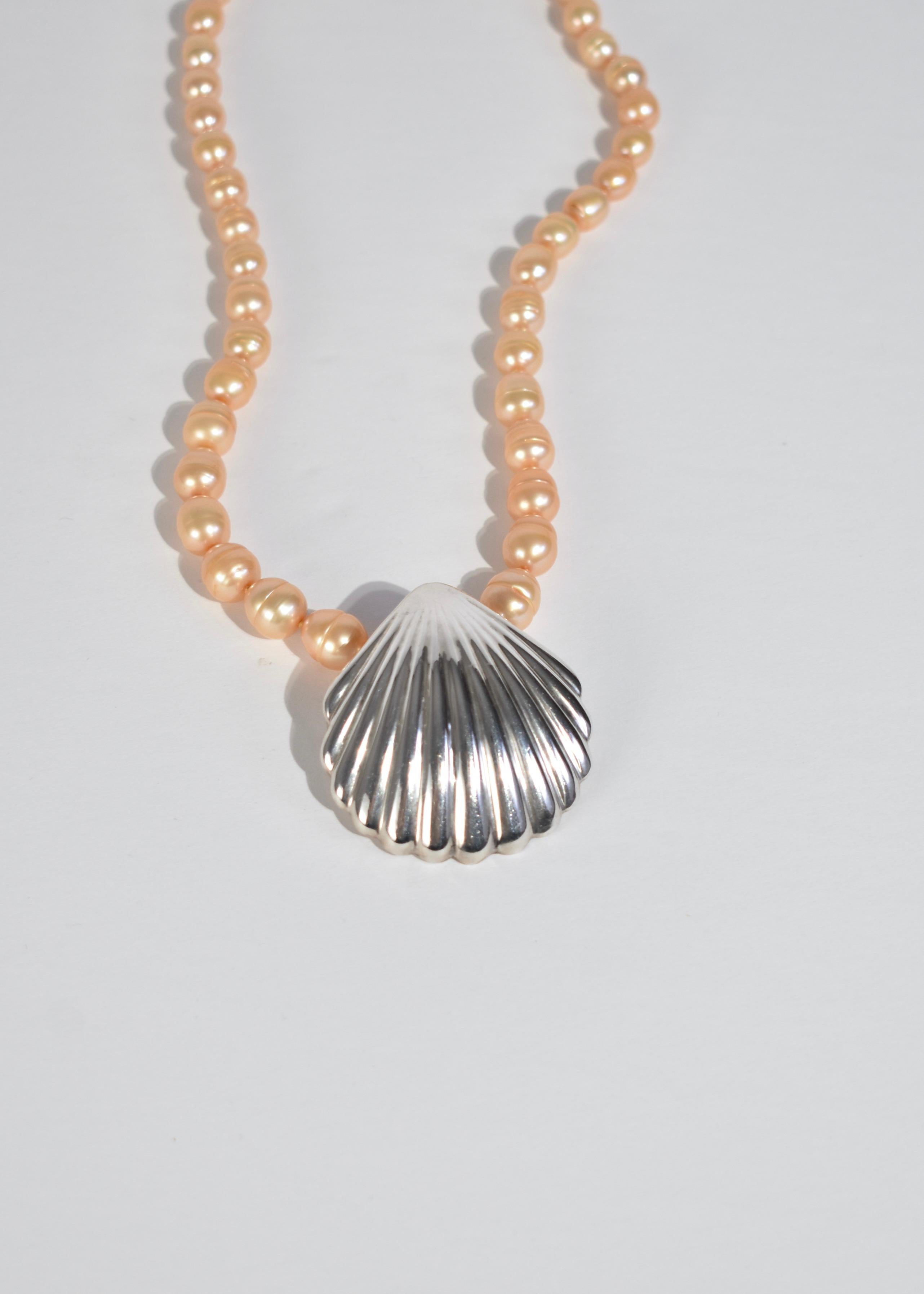 Vintage light yellow pearl necklace with oversized silver shell pendant and clasp closure. Stamped 925.

Material: Sterling silver, freshwater pearl.


