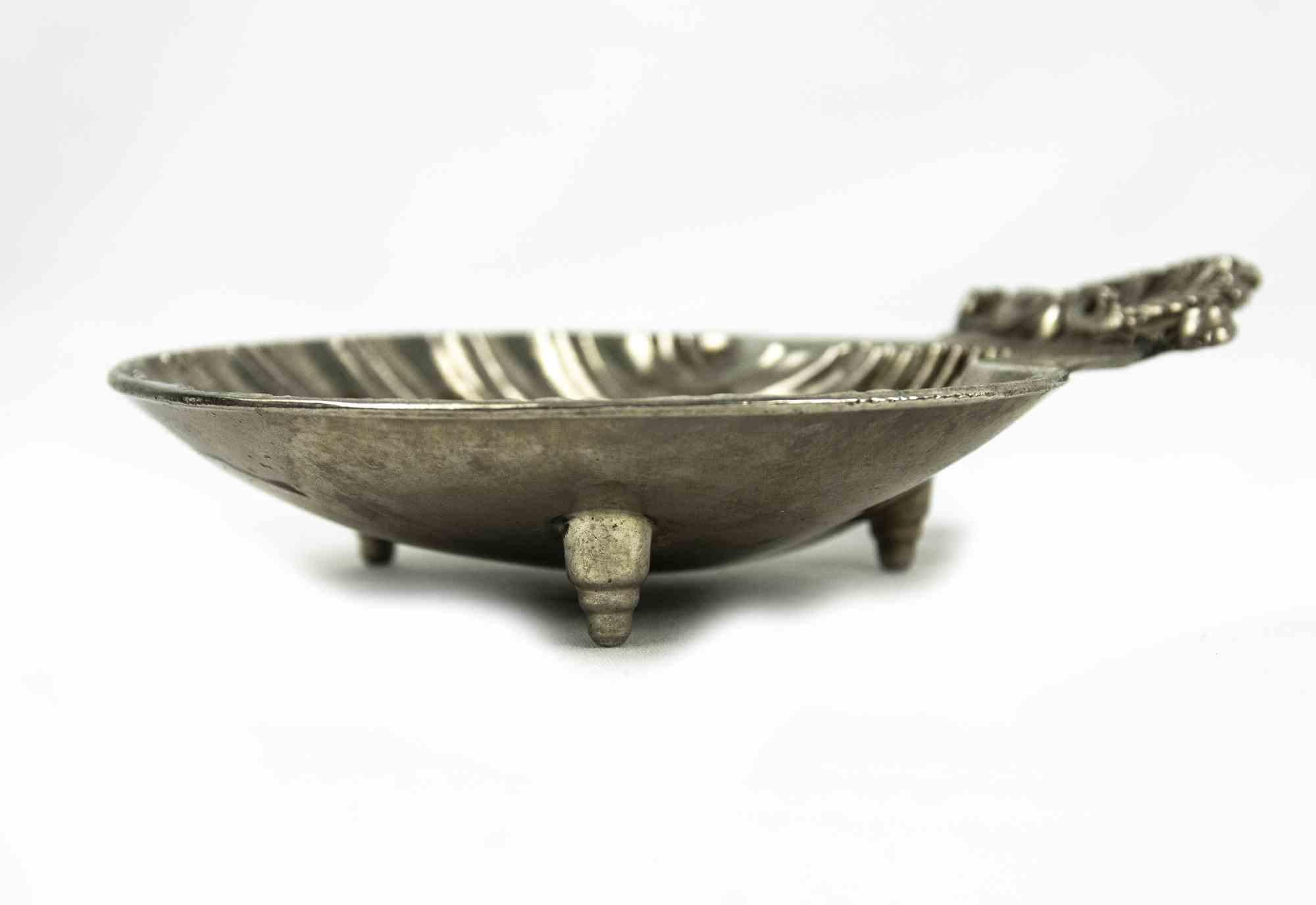 Shell shape vintage silver plated ashtray is an original decorative object realized in England in the 1970s.

Dimensions: 3 x 12.5 cm. 

Good Conditions. Some traces of ash are present.

The work reproduces an open shell valve and the handle