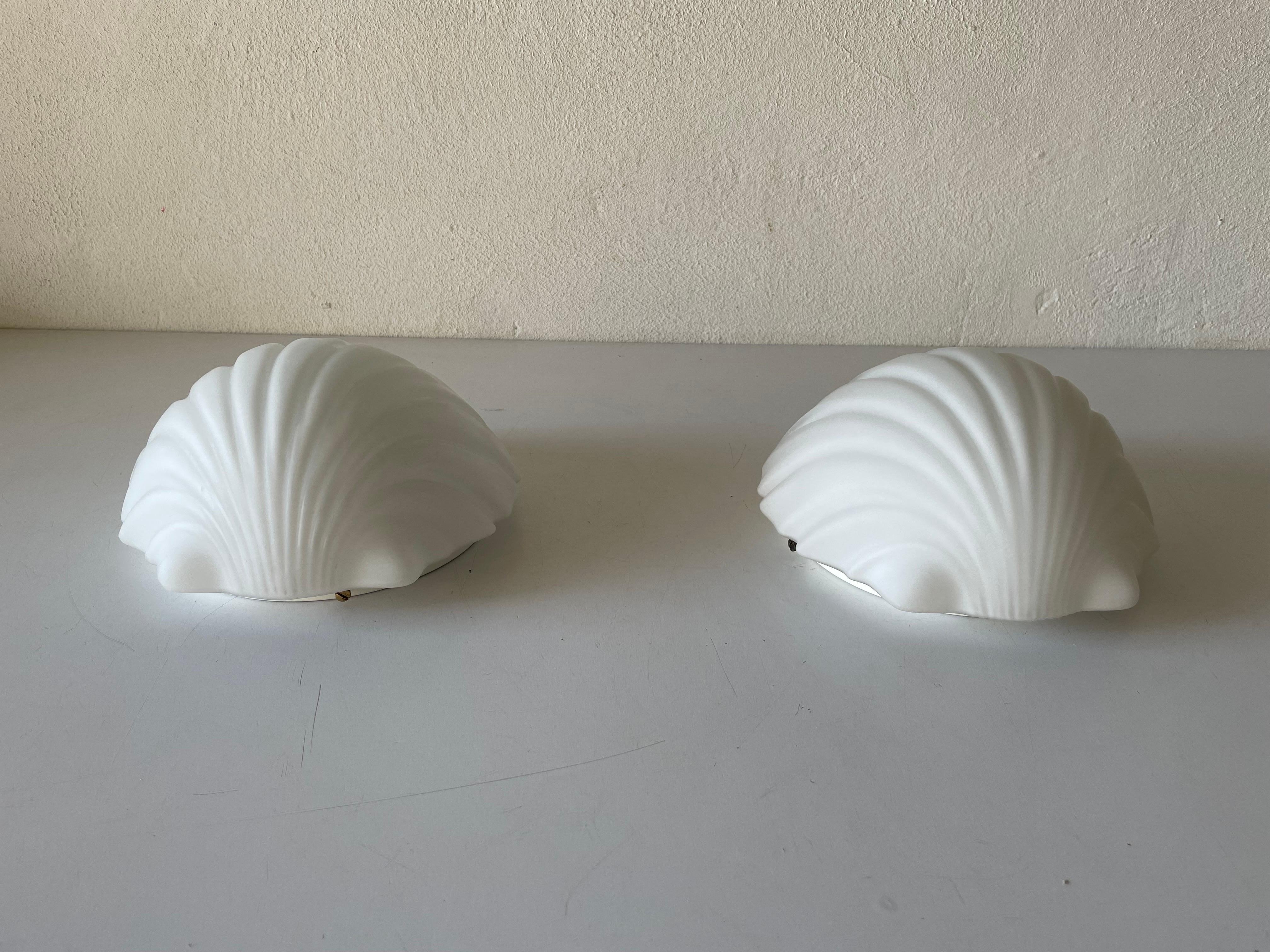 Shell shaped opal glass pair of wall lamps by Limburg, 1960s, Germany

Very elegant and Minimalist wall lamps

Lamps are in very good condition.

These lamps works with E27 standard light bulbs. 
Wired and suitable to use in all countries.