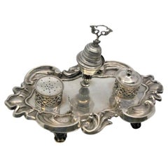 Shell-shaped silver inkwell w/ two tanks, bell 
standing on three hollow feet