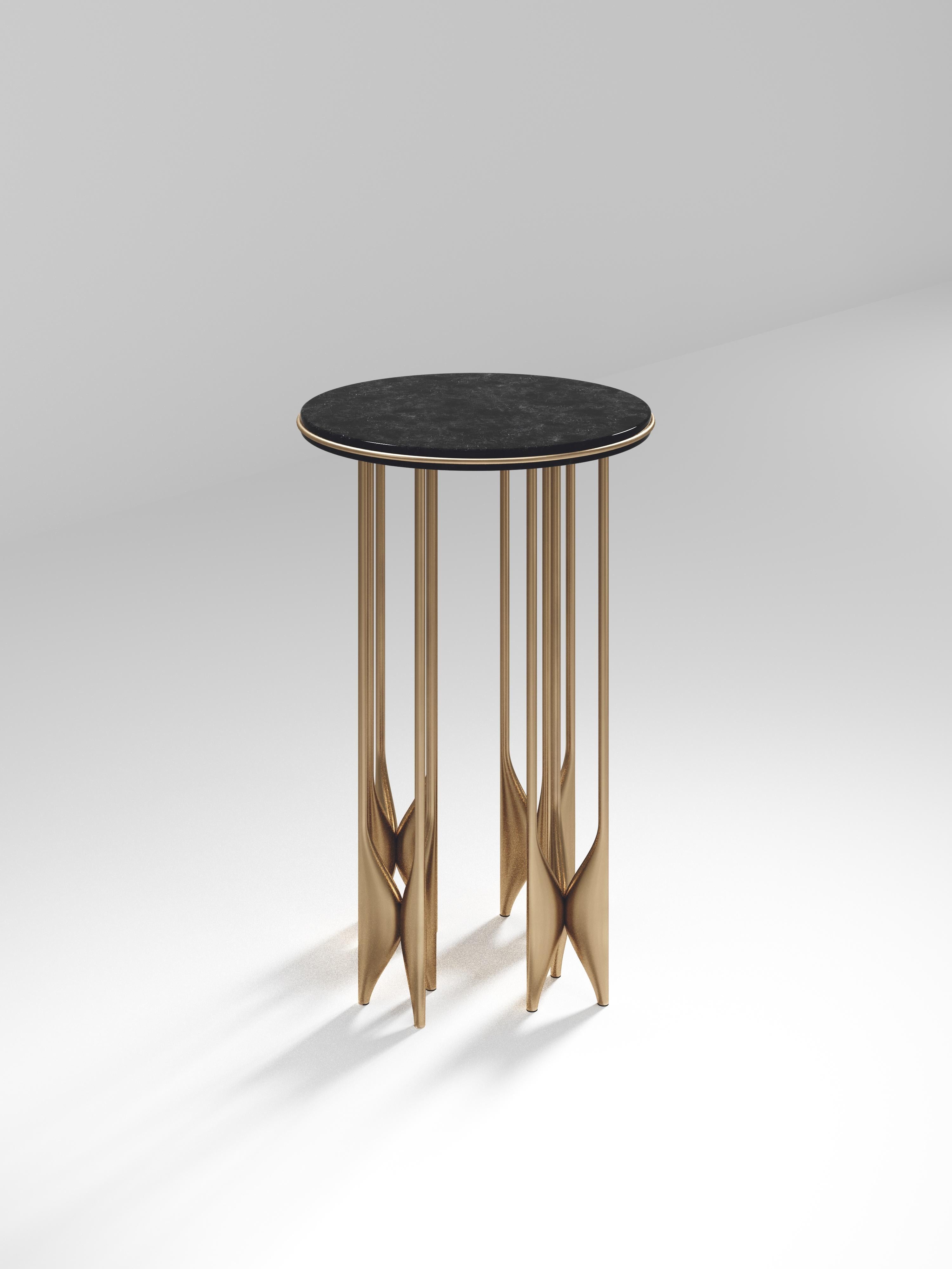 The Plumeria side table by Kifu Paris is a dramatic and sculptural piece. The black pen shell inlaid top sits on clusters of bronze-patina brass legs that are conceptually inspired by bird feathers floating on top of a lake. The border of the top is