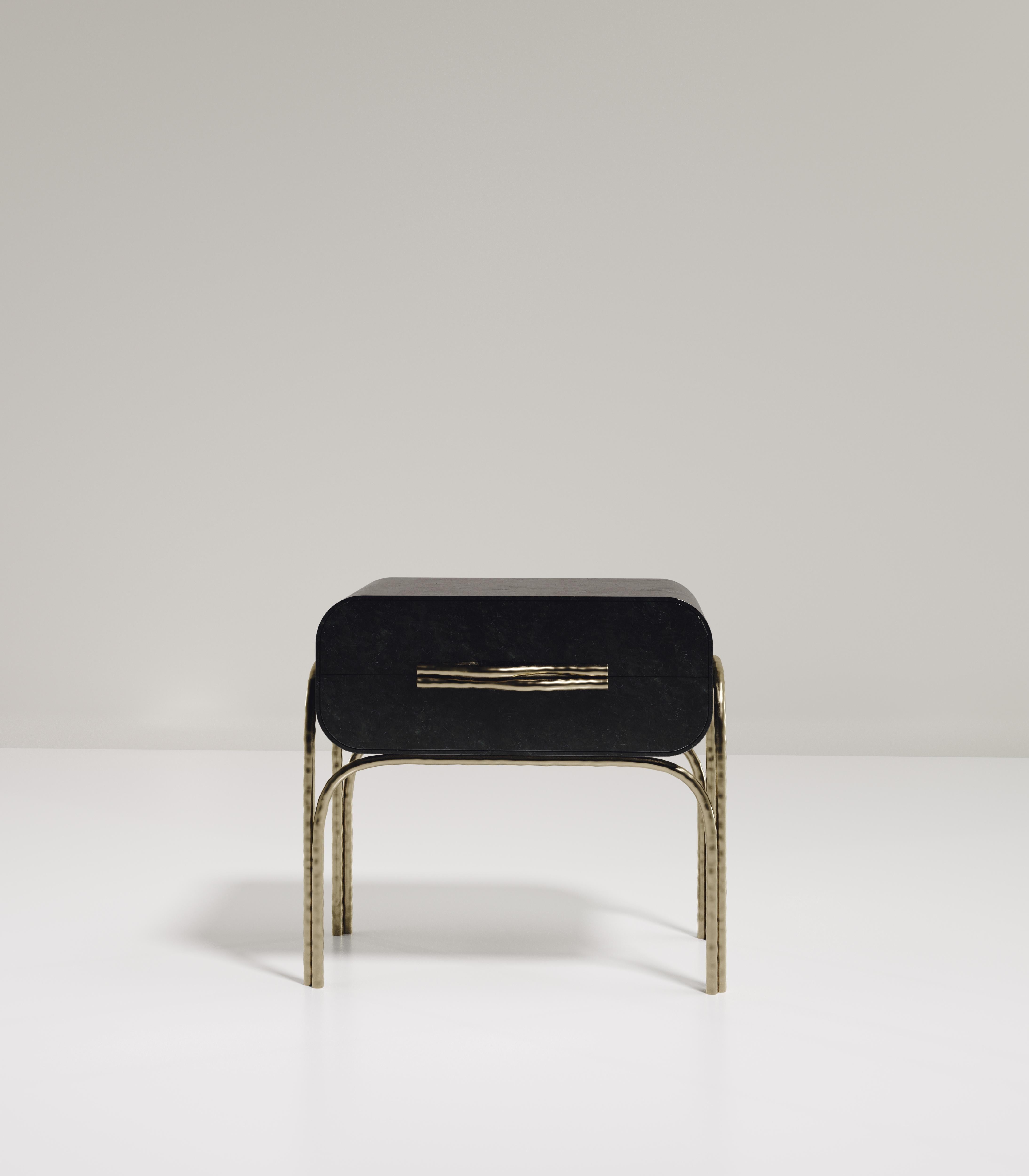 The Arianne side table by R&Y Augousti is an elegant piece for any space. The black pen shell top, with curved edges, sits on an organic bronze-patina frame. The intricate frame and legs have a 
