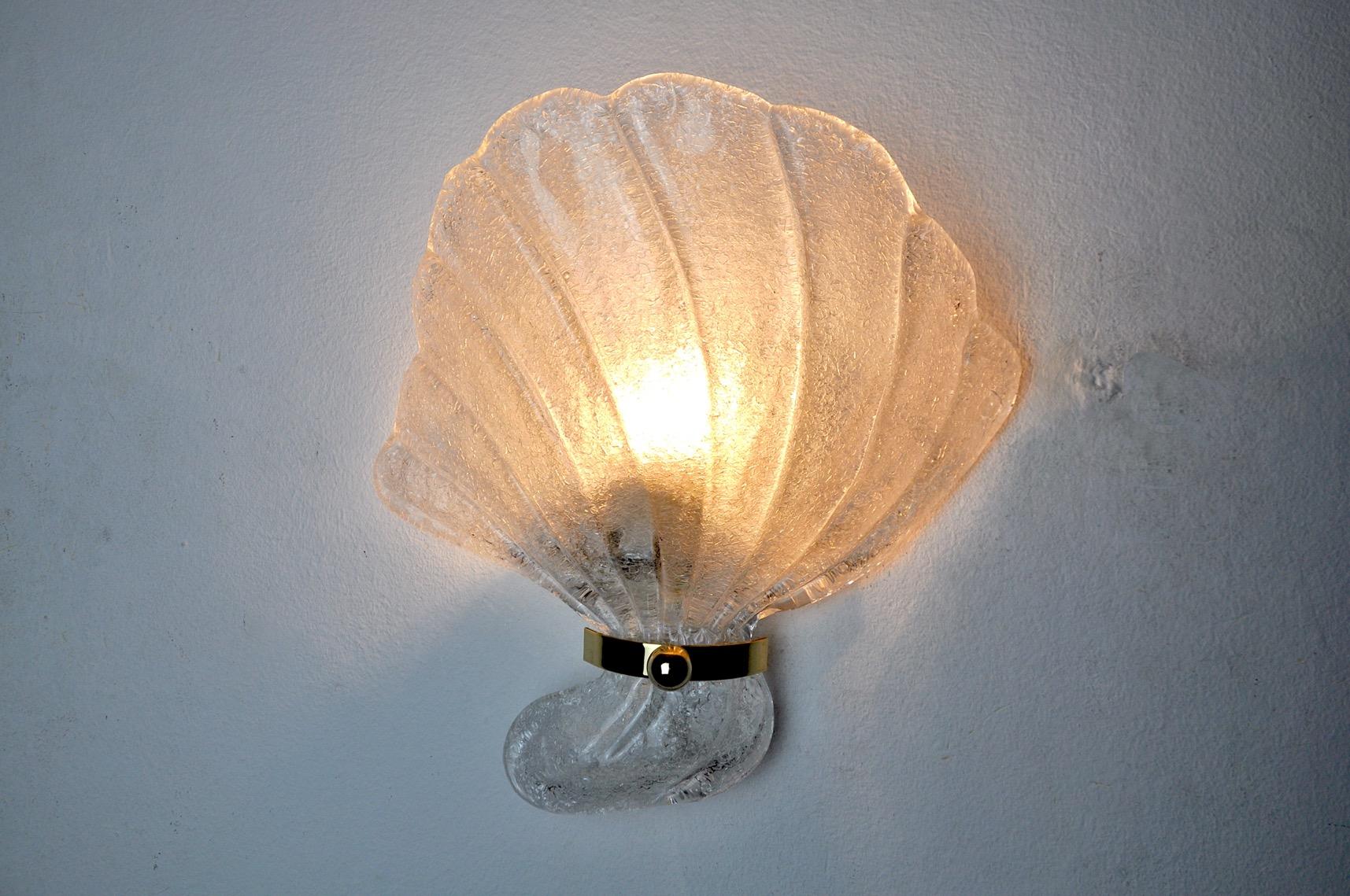 Large and rare shell wall lamp in murano glass, designed and produced in italy in the 1970s.

Wall lamp refers to in the shape of a shell supported by a golden and white metal structure.

Unique object that will illuminate wonderfully and bring